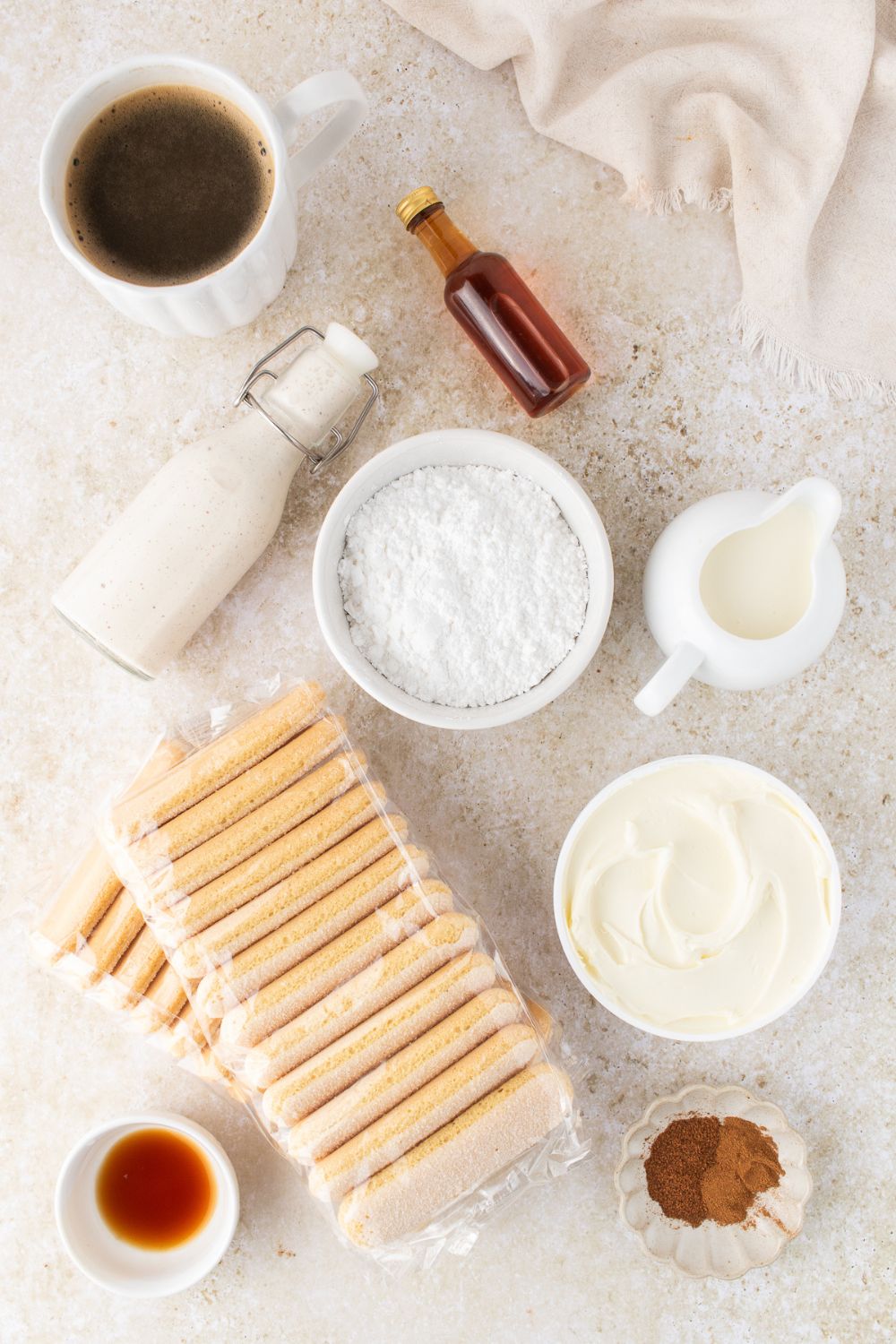 ingredients to make eggnog tiramisu in single serve white bowls on a white counter