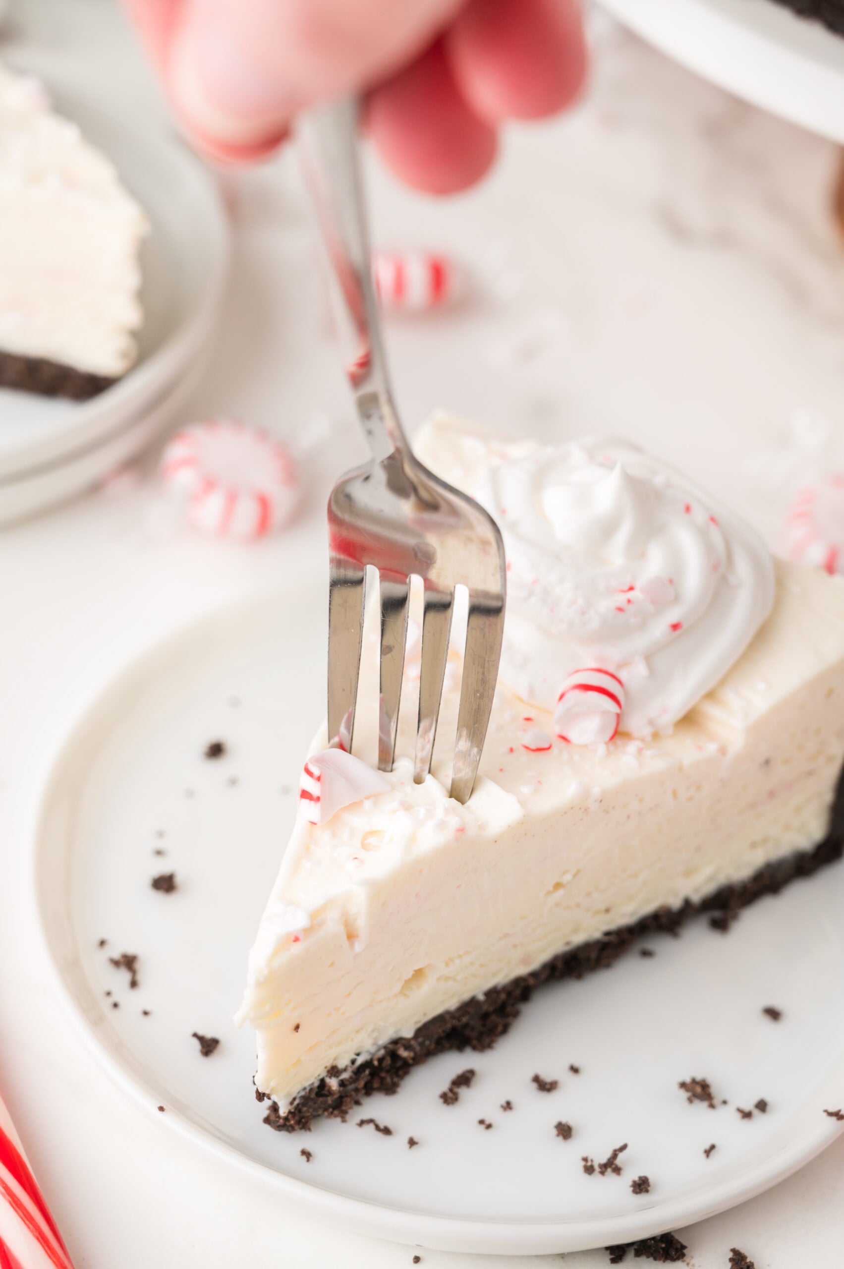 a slice of No Bake Peppermint Cheesecake with a fork going into it to take a bite