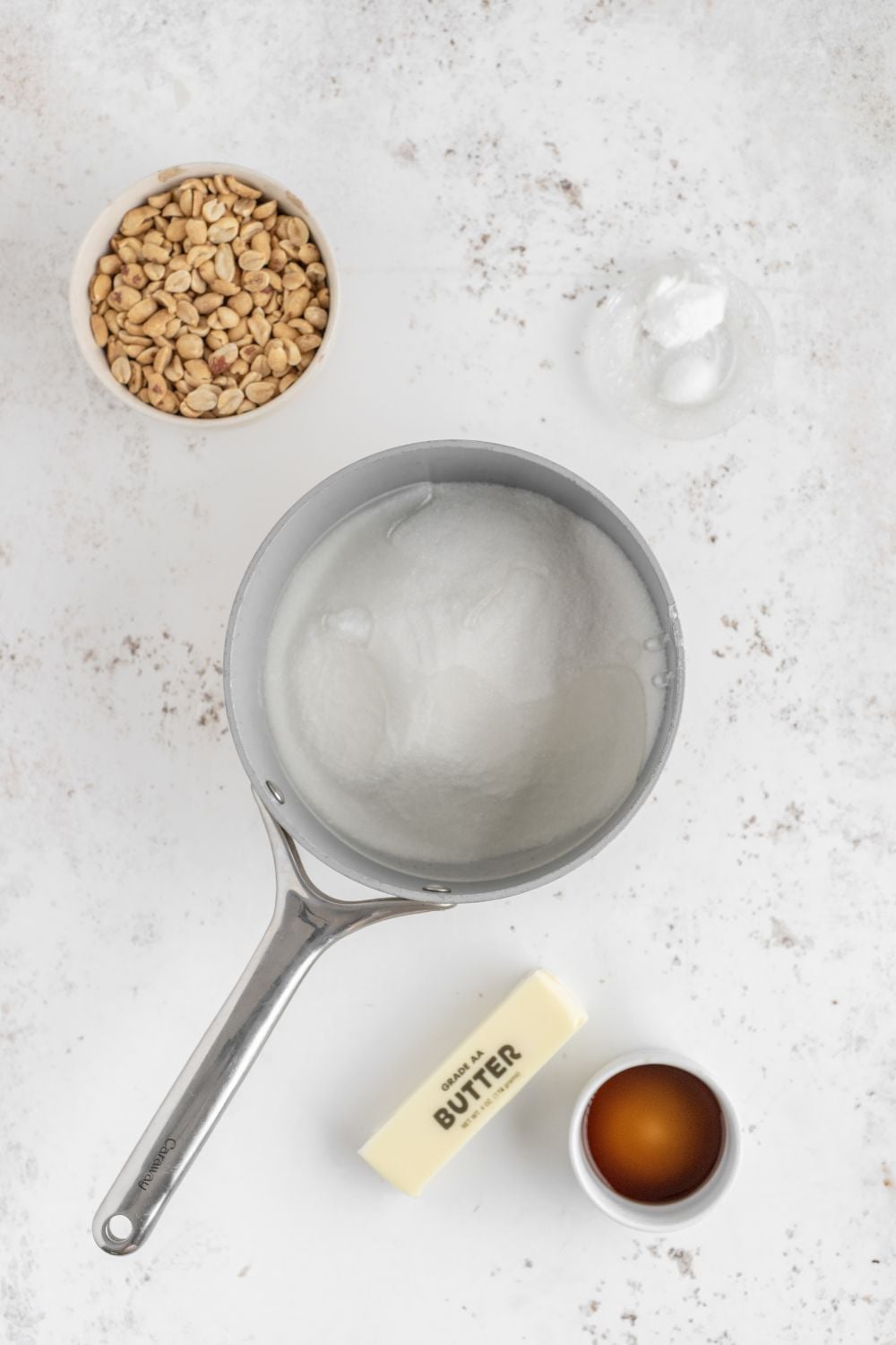 sugar in a saucepan with other ingredients to make brittle around table