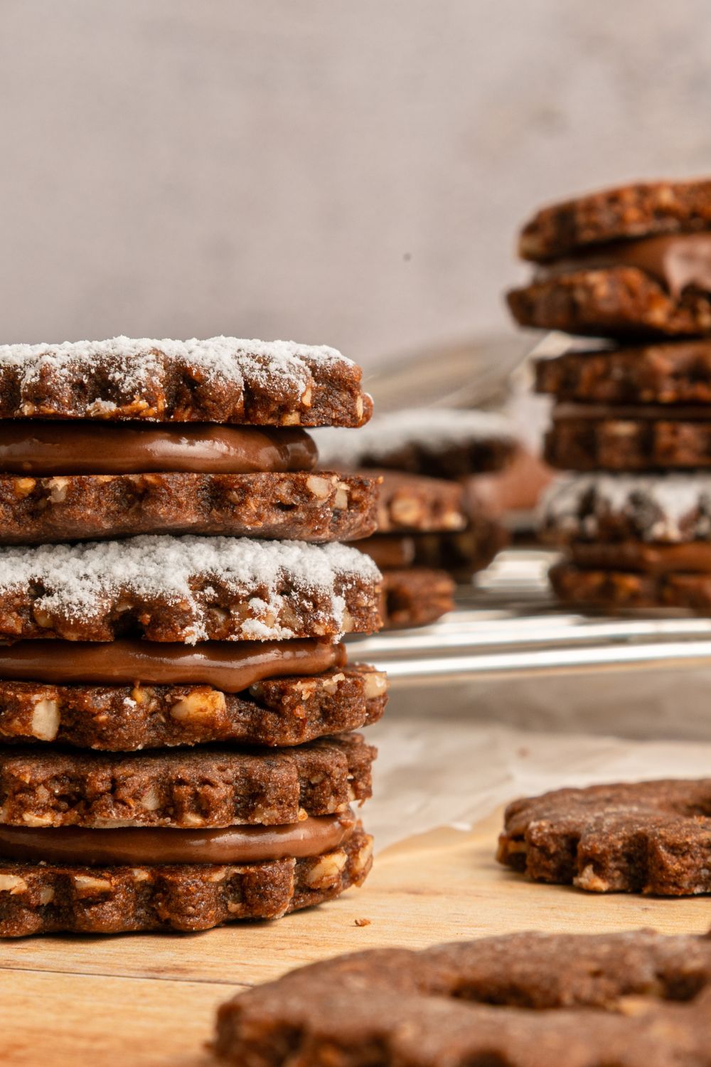 Chocolate Linzer Cookies in stacks around the table 