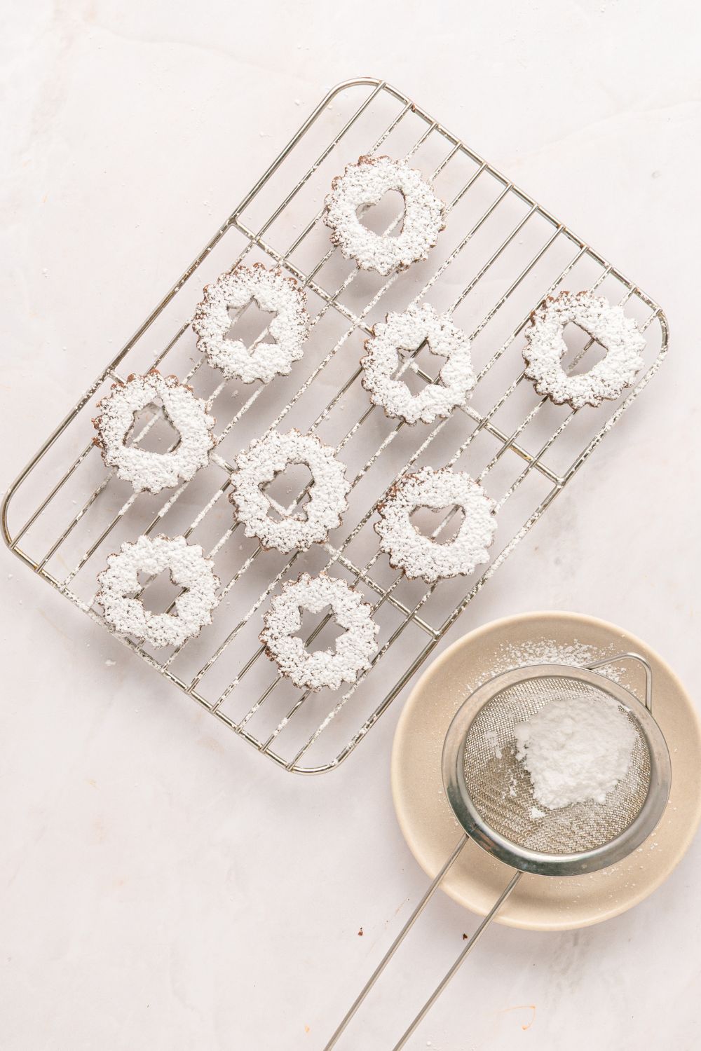 powdered sugar dusted chocolate linzer cookies shaped like stars 