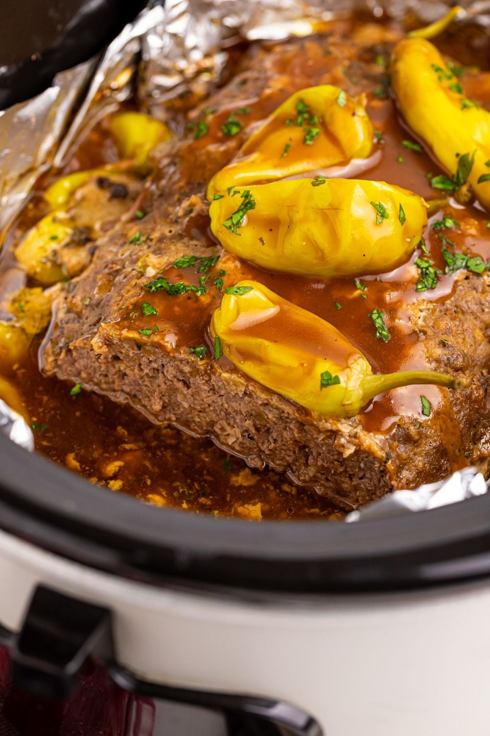 close up of Crockpot Mississippi Meatloaf with peppers and gravy on top