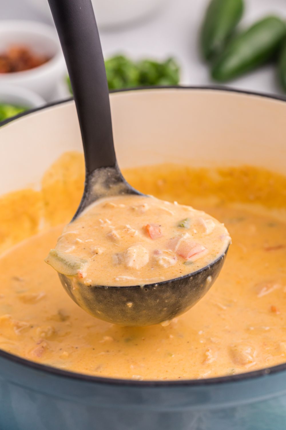 stockpot with jalapeño popper crack chicken soup with a ladle scooping up some of the the soup