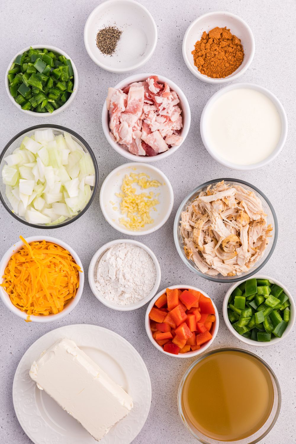 bowls full of ingredients for the soup on the table for making jalapeño popper crack chicken soup
