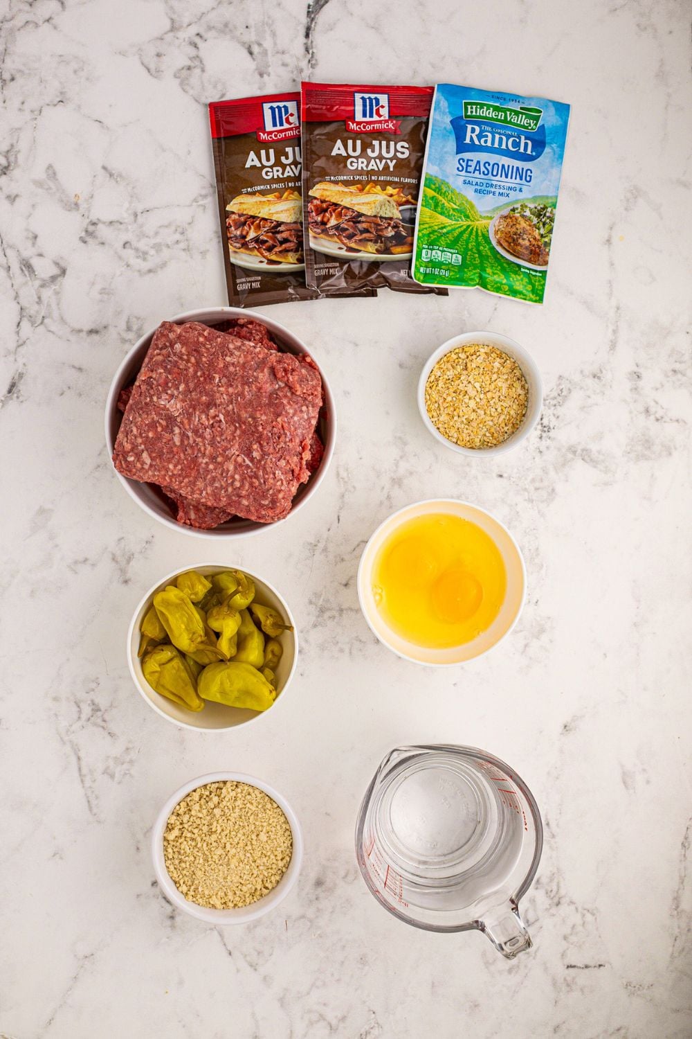 all the ingredients for Crockpot Mississippi Meatloaf in single serve containers on a white table