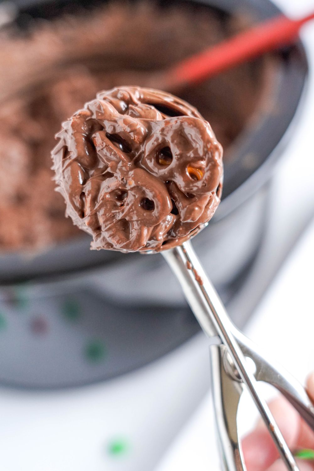 cookie scoop full of Crockpot Chocolate Pretzel Christmas Candy