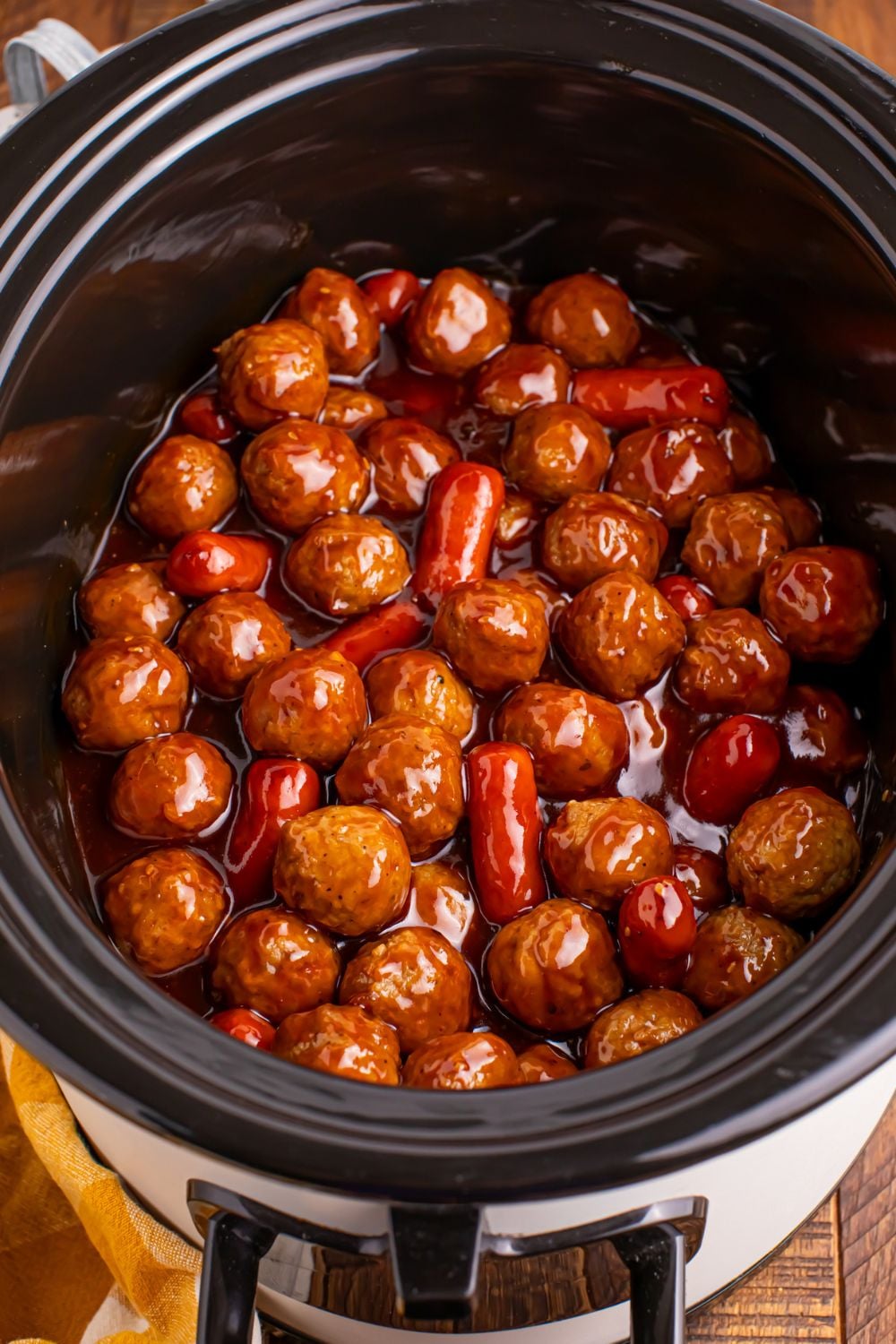 looking down on table and you see a crockpot full of teriyaki meatballs and lil smokies 