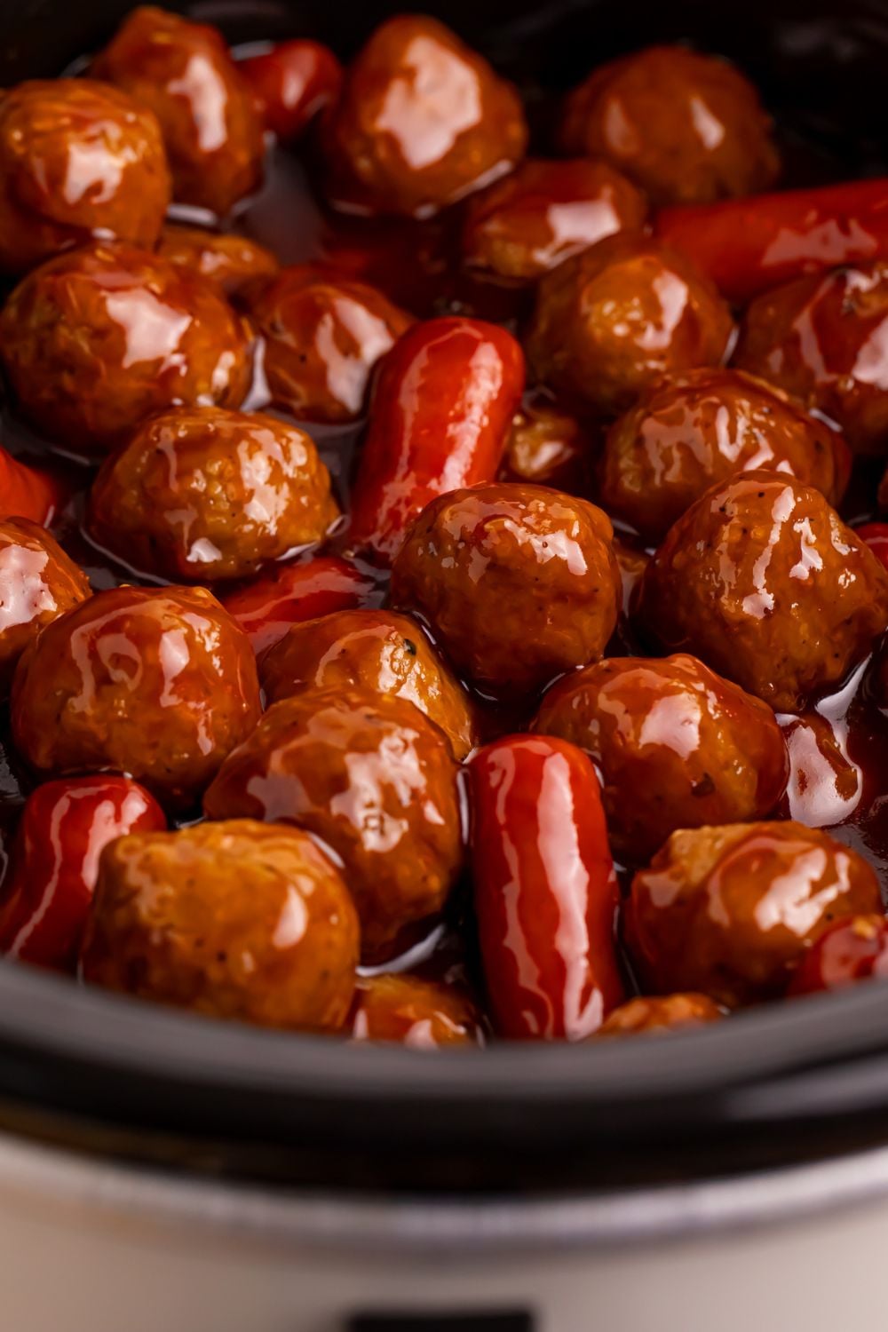 Crockpot Teriyaki BBQ Cocktail Meatballs & Lil Smokies in a crockpot showing a close up of the sauce coating all the meatballs and smokies 
