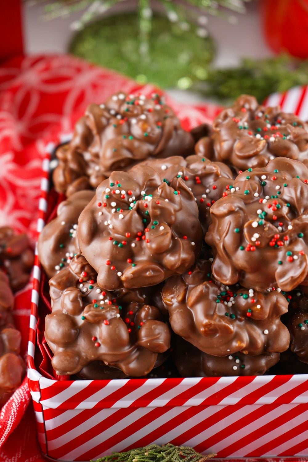 Crockpot Christmas Candy in a red and white striped tin on a red table