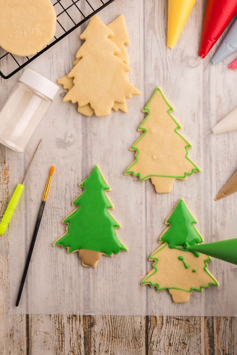 tree shaped ornament sugar cookies being piped with royal icing