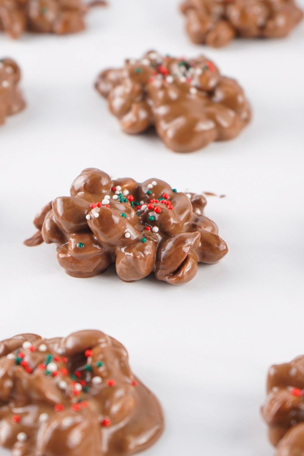 Crockpot Christmas Candy on parchment paper with sprinkles on top
