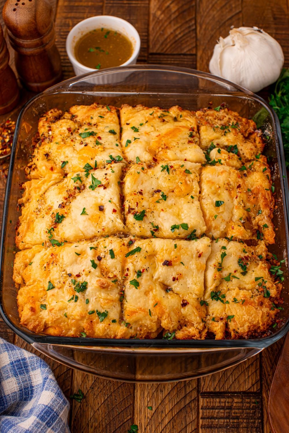 looking at the table with a pan of cowboy butter biscuits and then a garlic and small bowl of seasonings
