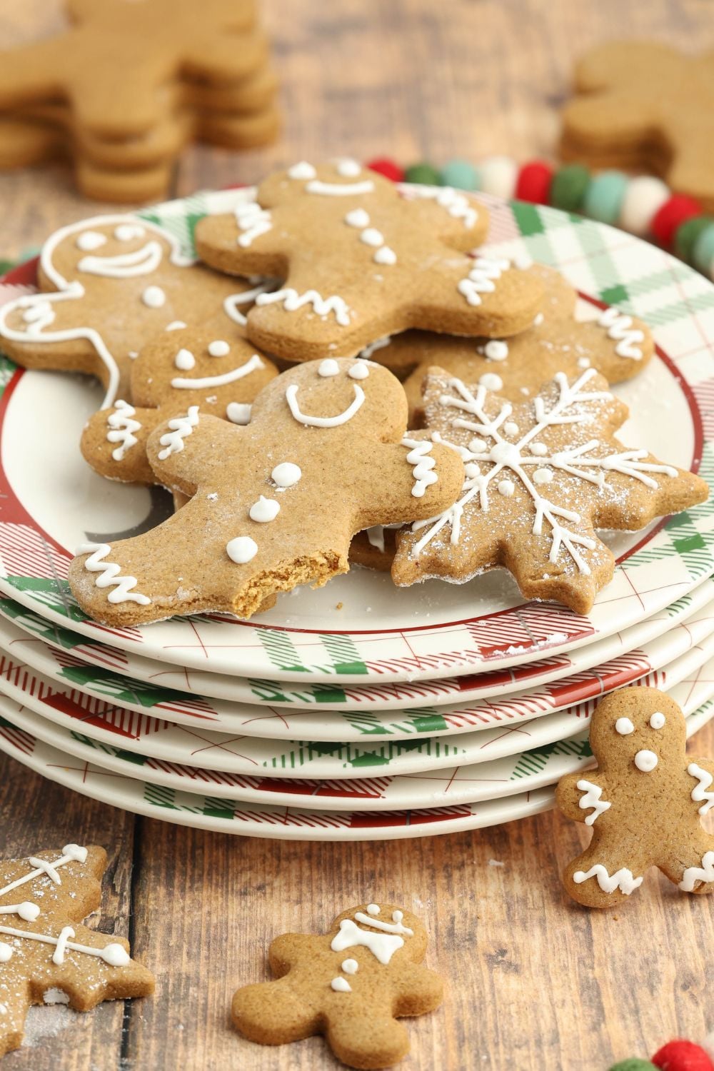stack of plates and on top is gingerbread cookies with one with a bite taken out of it 