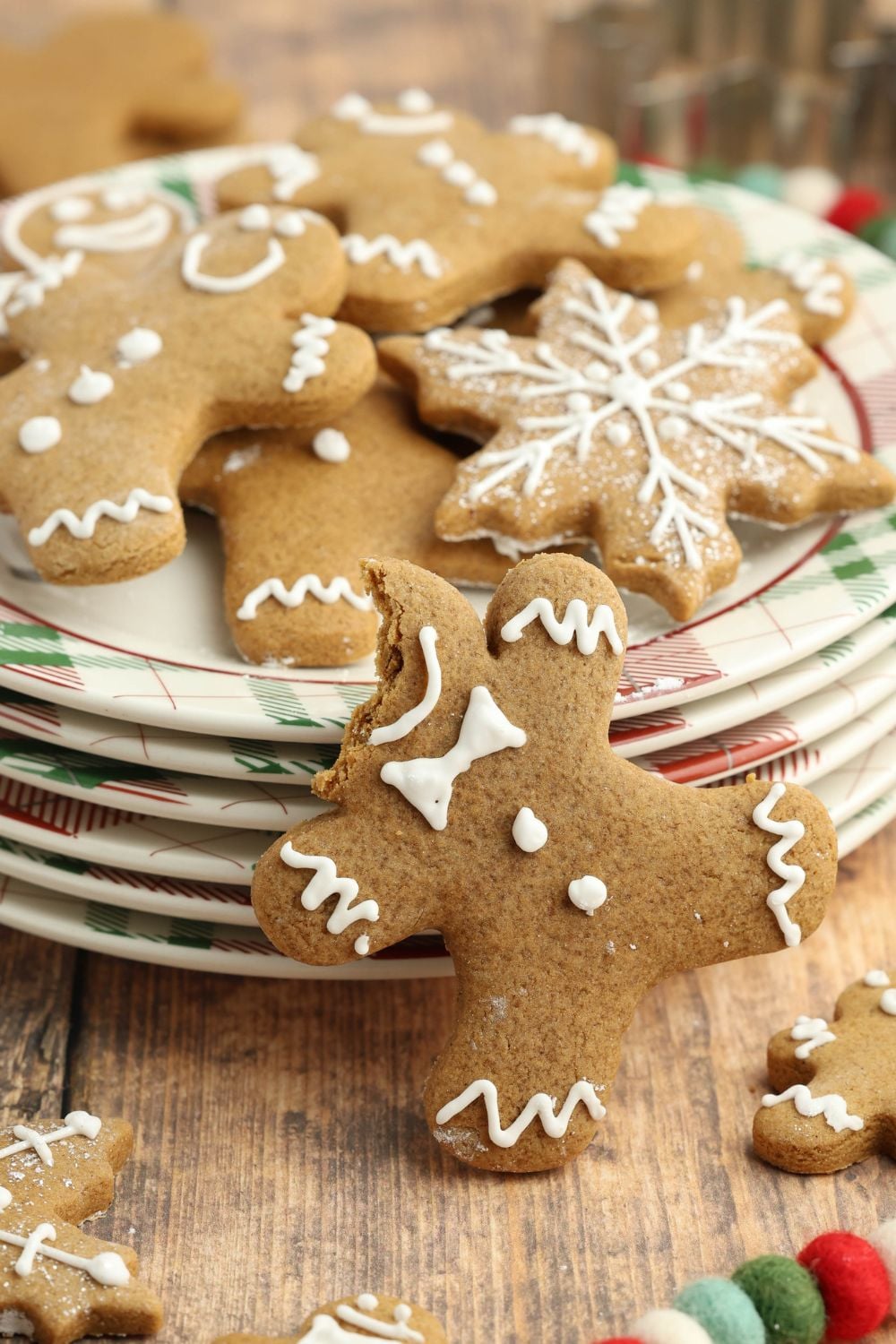 bite taken off head of gingerbread man on a stack of plates