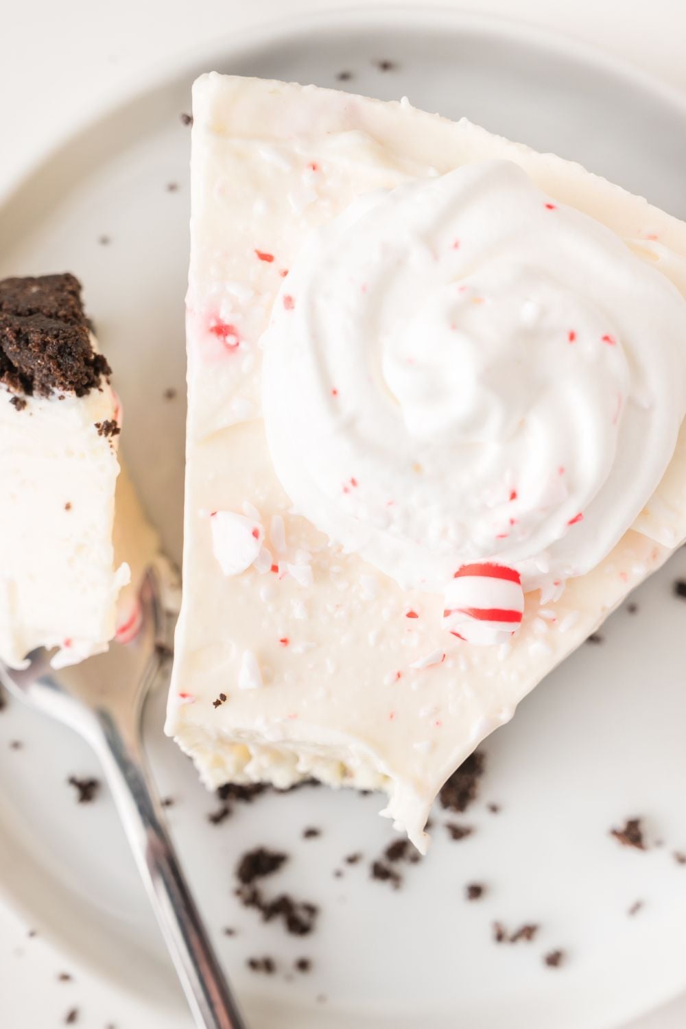 slice of No Bake Peppermint Cheesecake on plate with a fork to side on plate 