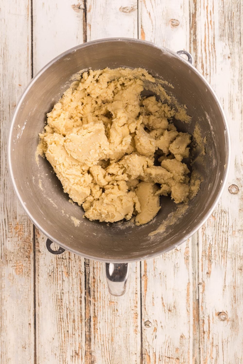 creamed butter and sugar in a metal bowl on table for sugar cookie dough