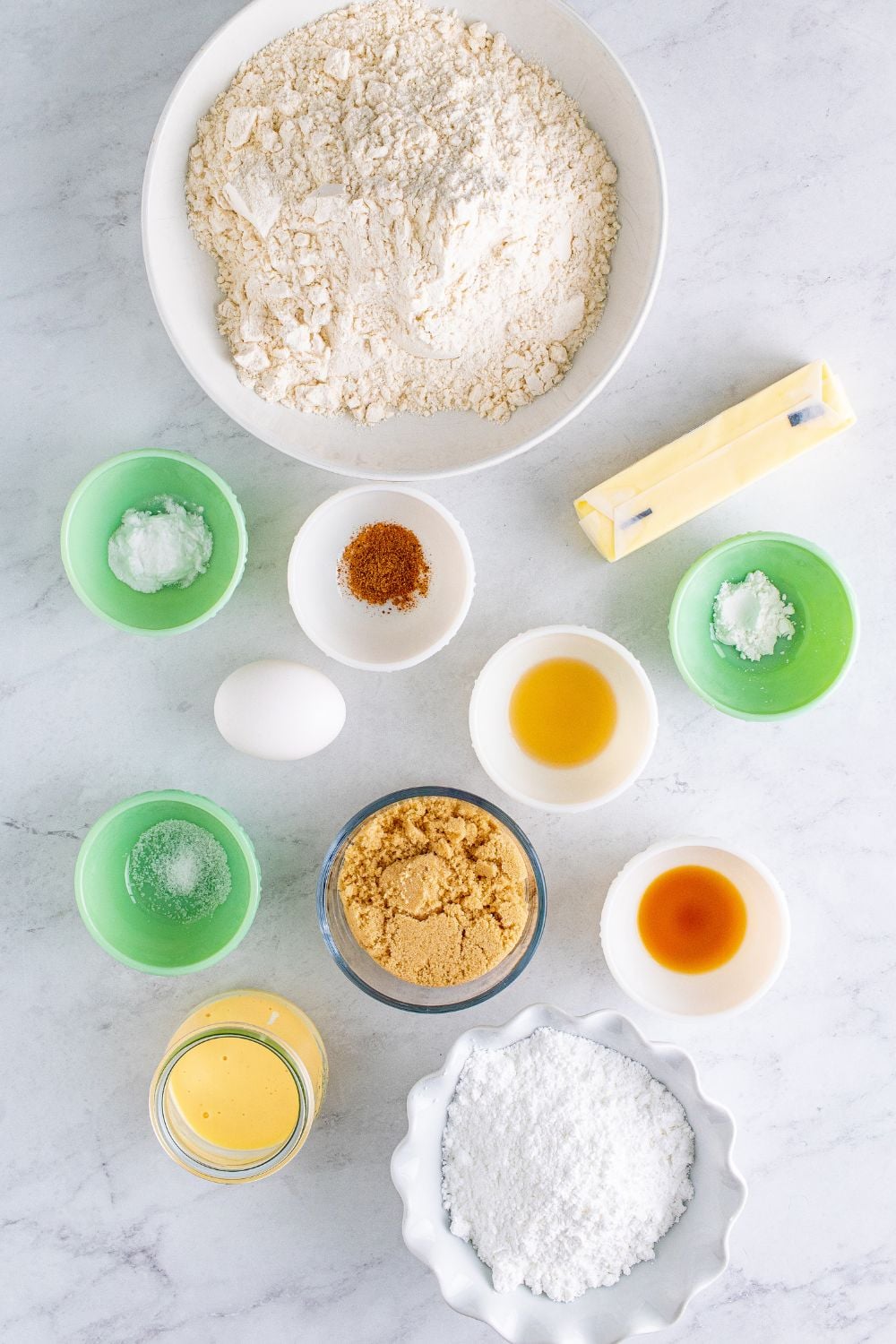 ingredients for Soft Frosted Eggnog Cookies in single serve containers on table
