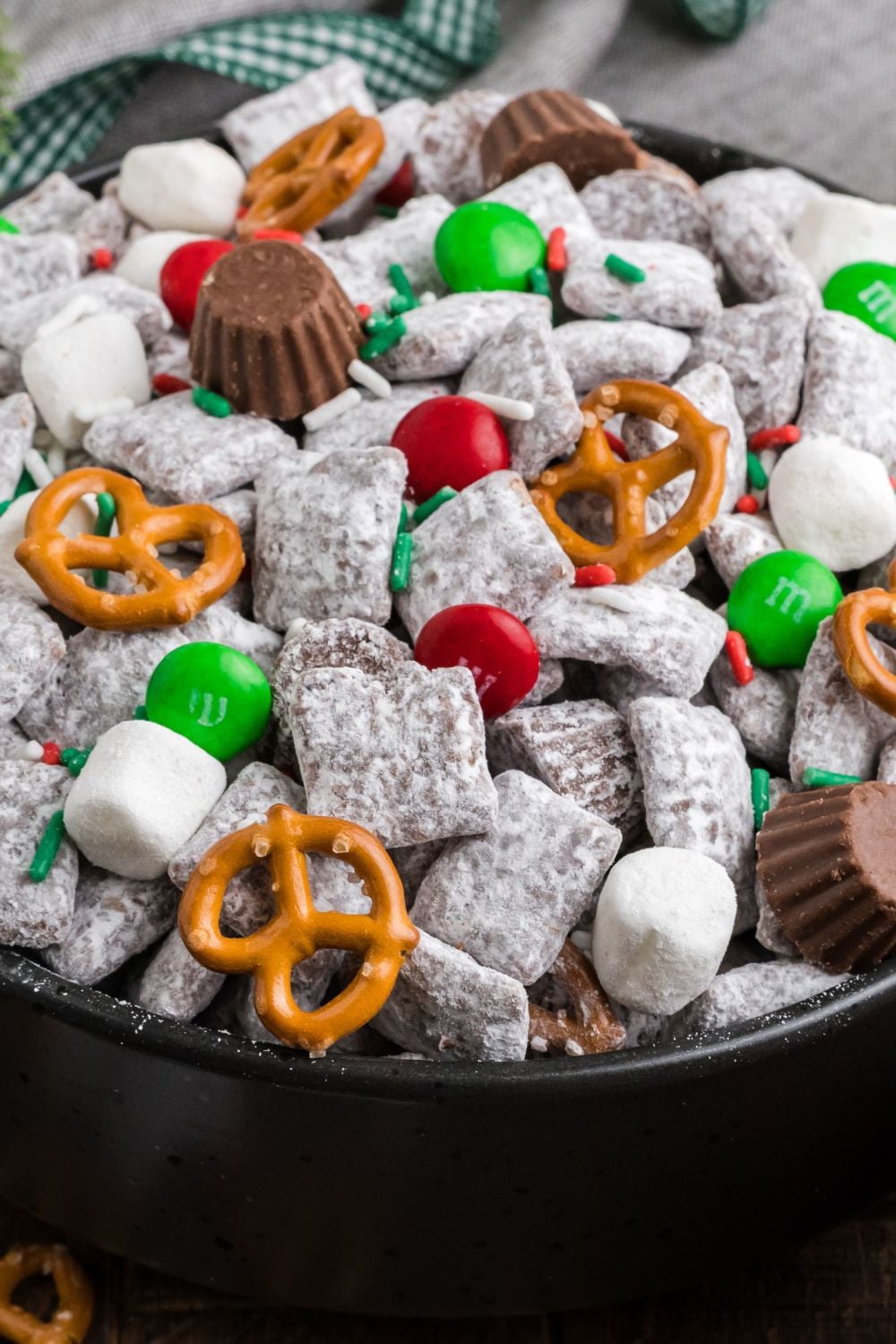 close up view of Christmas Chex Mix in a black bowl on table