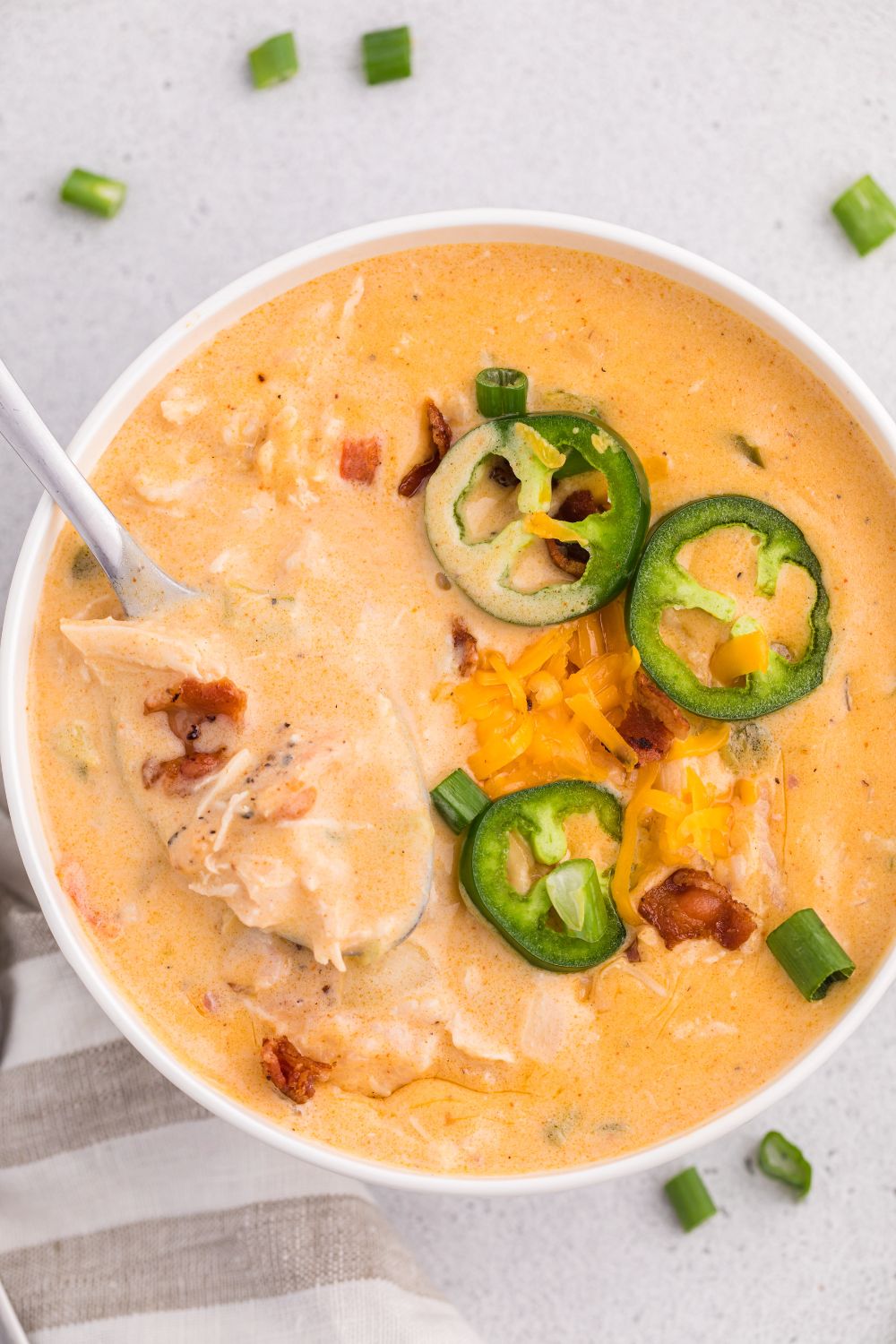 jalapeño popper crack chicken soup in a white plate with jalapeno slices