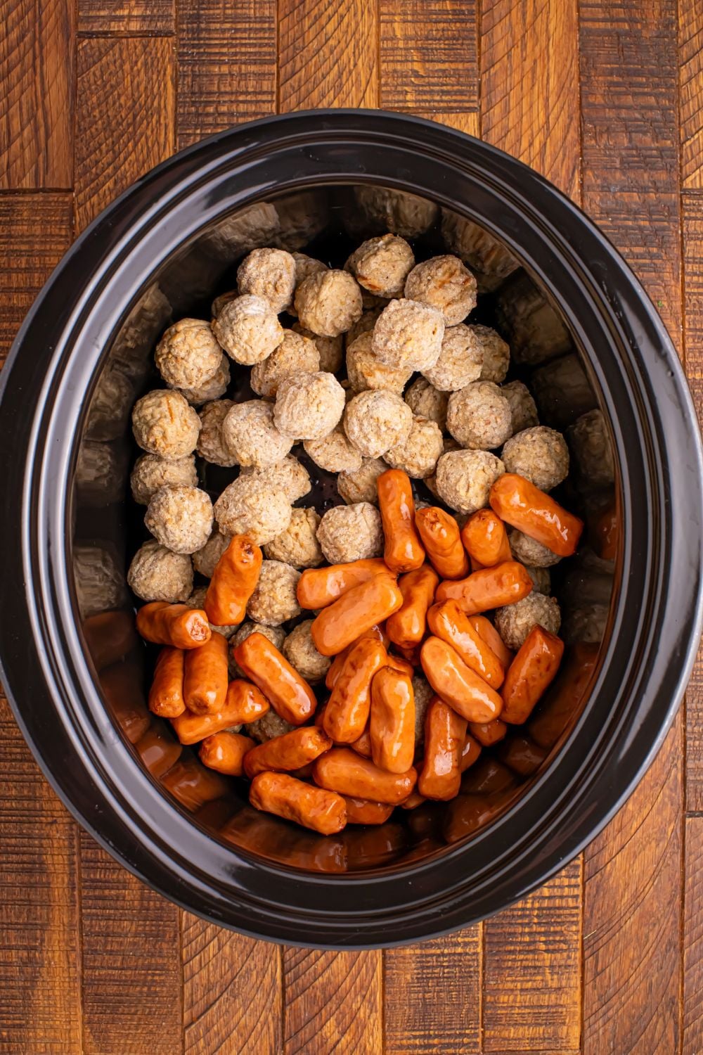 frozen meatballs and little smokies in a crockpot sitting on the table