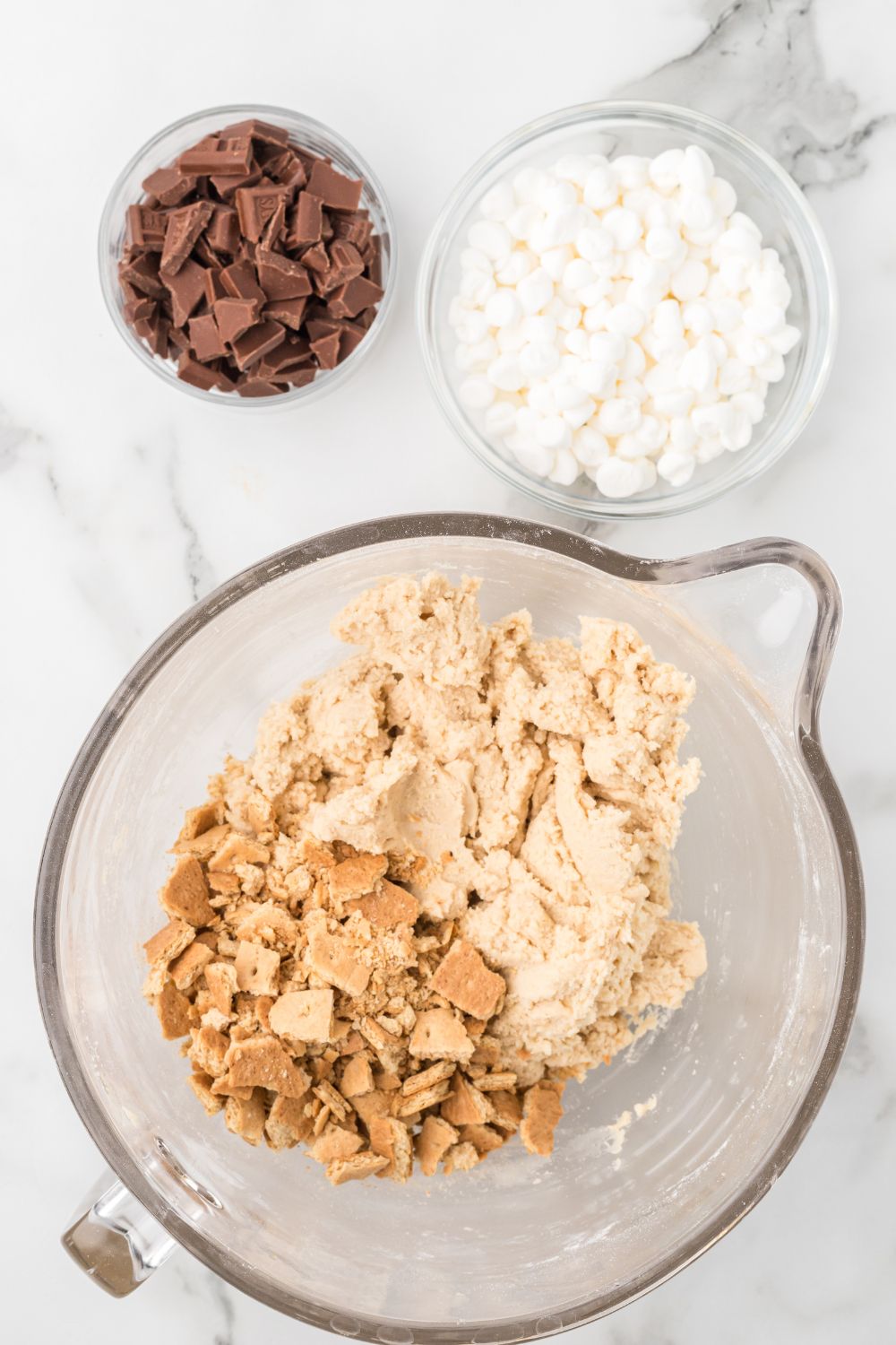 working to mix up all the mix-in ingredients for these smore cookies