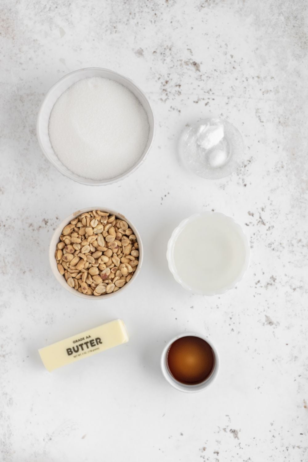 all the ingredients for Homemade Peanut Brittle in small glass bowls on table