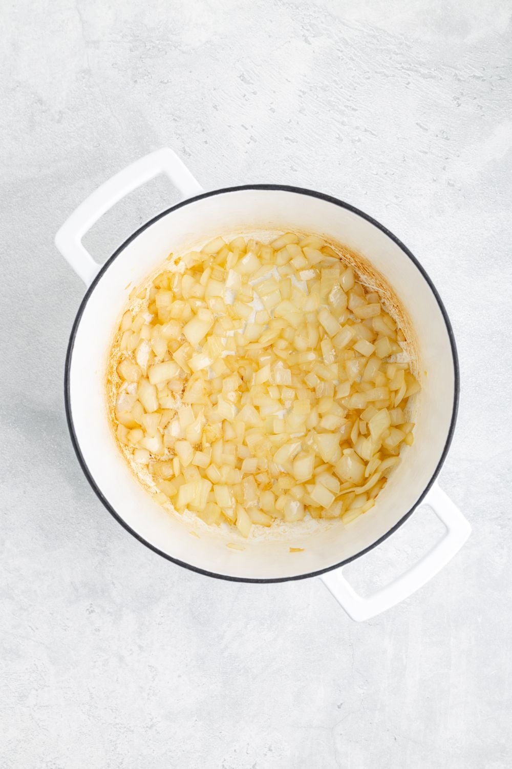 sauted onions in a white pot sitting on a white counter