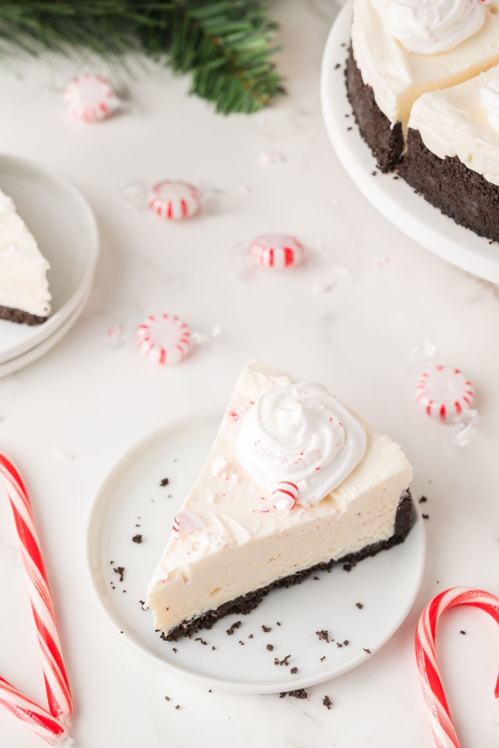 slices of No Bake Peppermint Cheesecake with candy canes around the table 