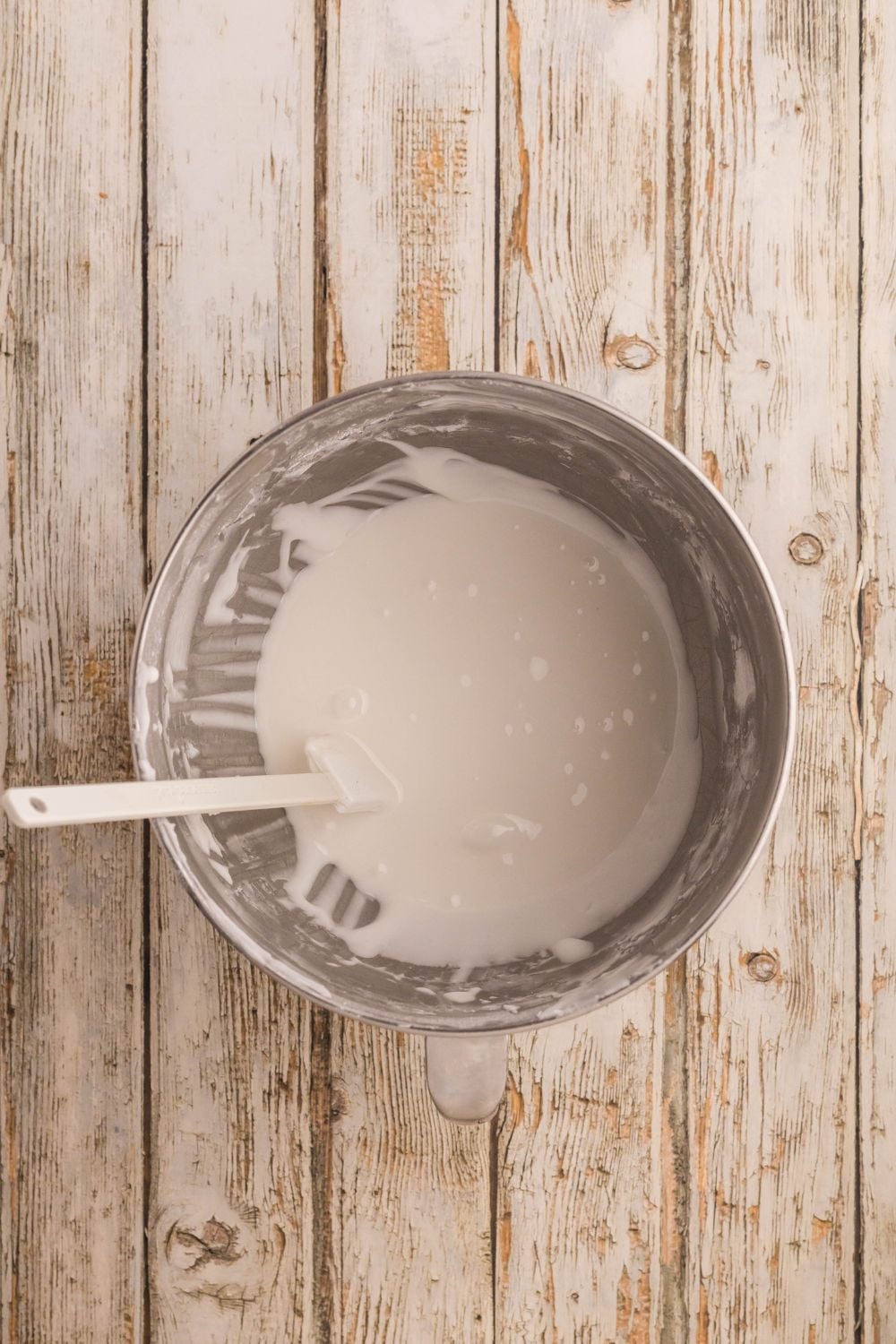 metal bowl with royal icing being mixed
