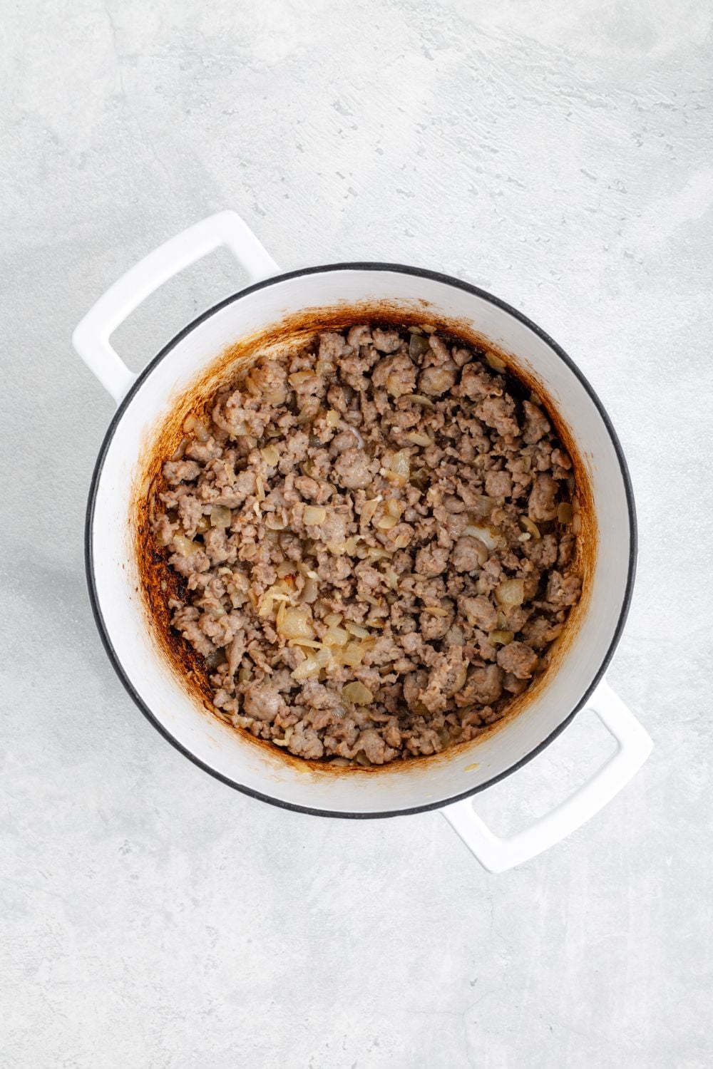 cooked ground sausage in a white pot sitting on a white table