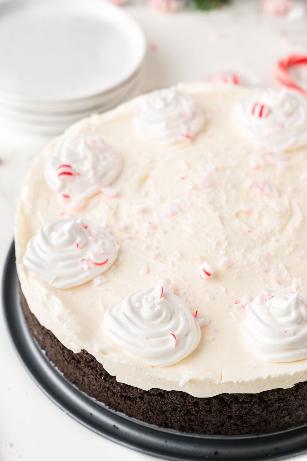 No Bake Peppermint Cheesecake on table with plates behind it on table 