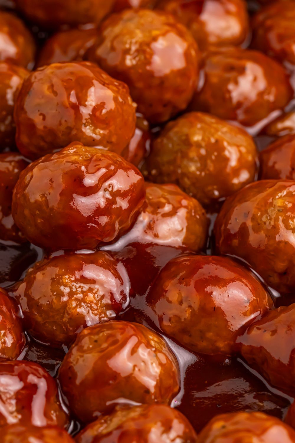 Peach BBQ Meatballs being cooked in a skillet full of sauce