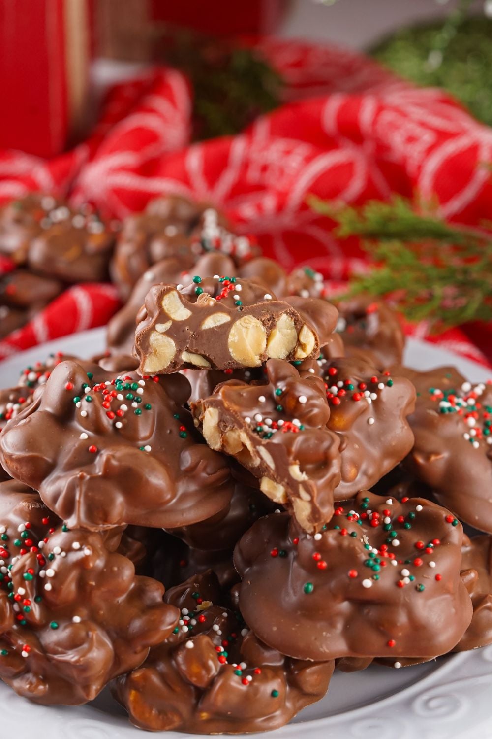 Crockpot Christmas Candy stacked on a white plate on table with a red towel behind it on table