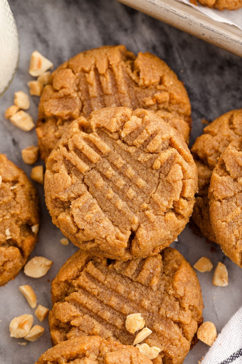 4 Ingredient Peanut Butter Cookies spread around the table with peanuts around the table