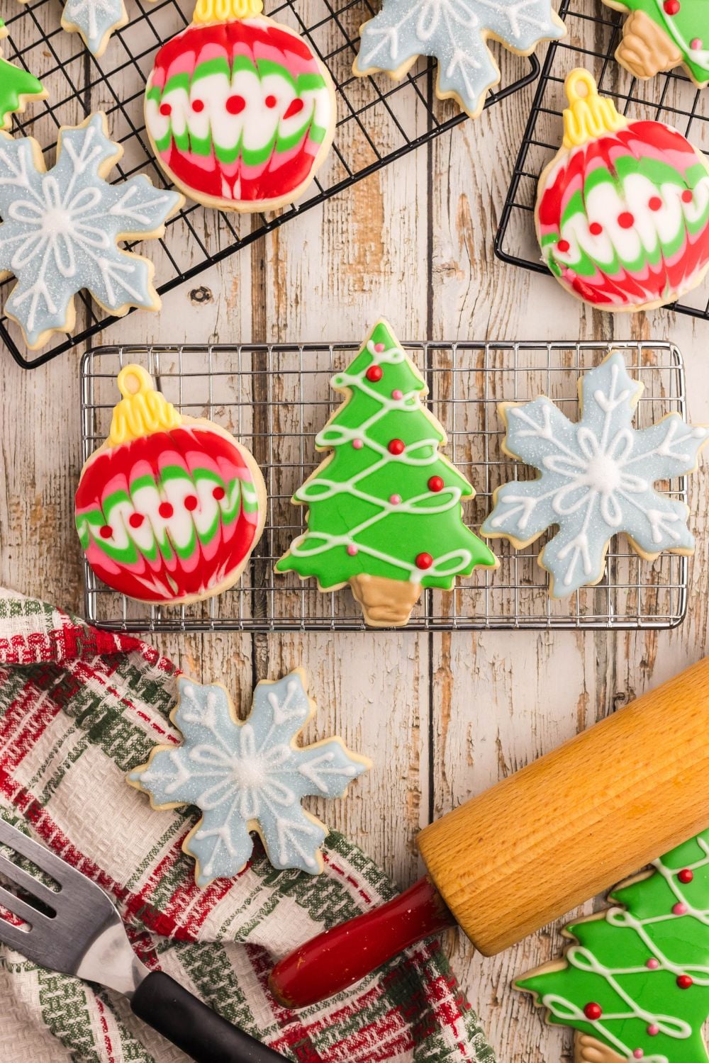 cooling rack with Christmas shaped ornaments and a rolling pin in front of rack on table