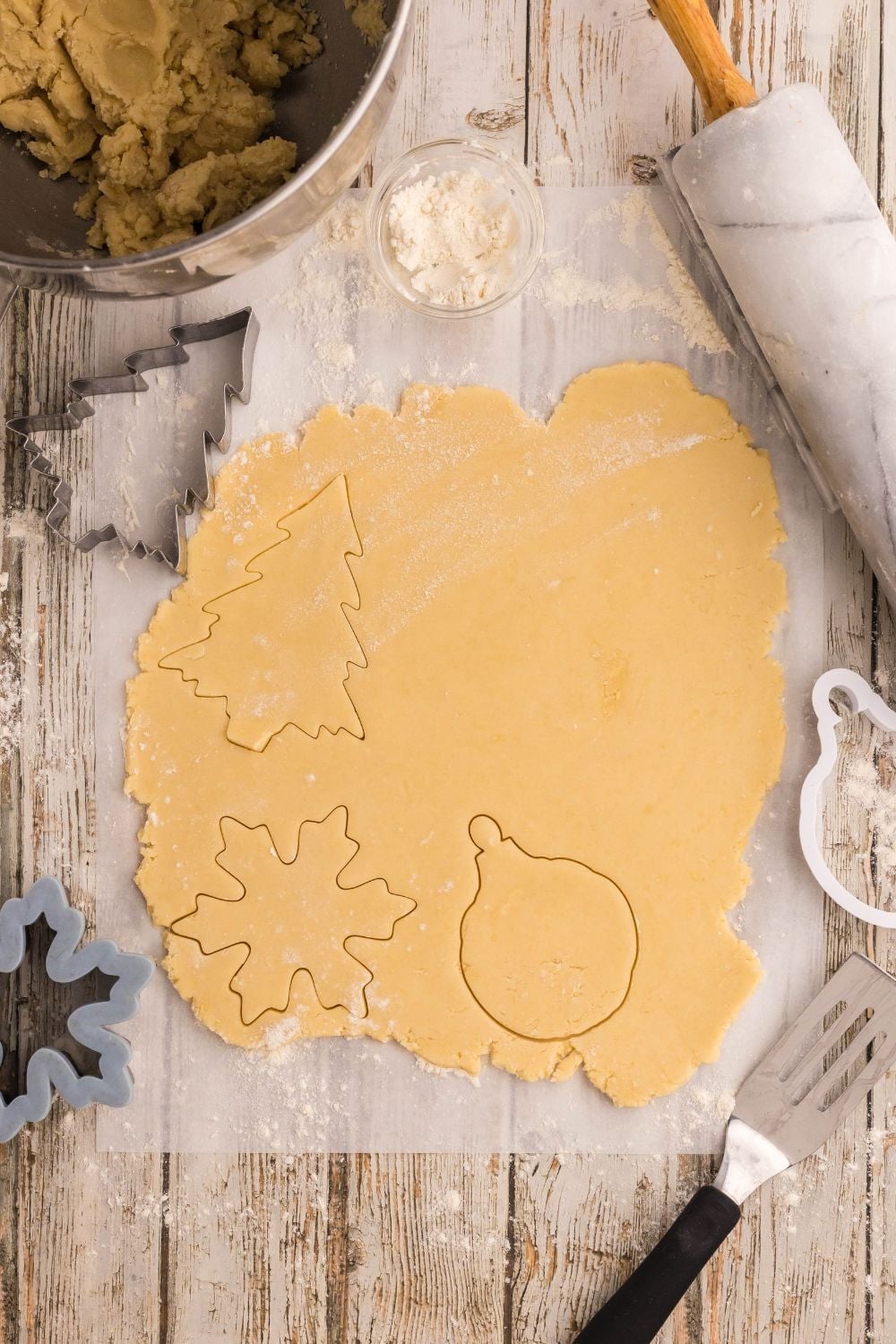 rolled out sugar cookie dough with christmas shapes