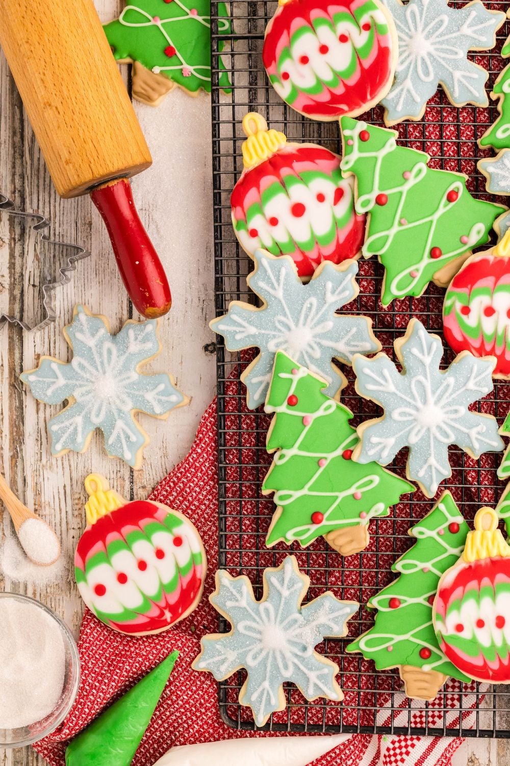 Decorated Christmas Sugar Cookies scattered on the table with a rolling pin to side