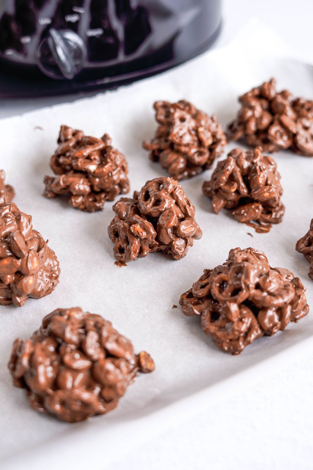 scoops of Crockpot Chocolate Pretzel Christmas Candy on parchment paper