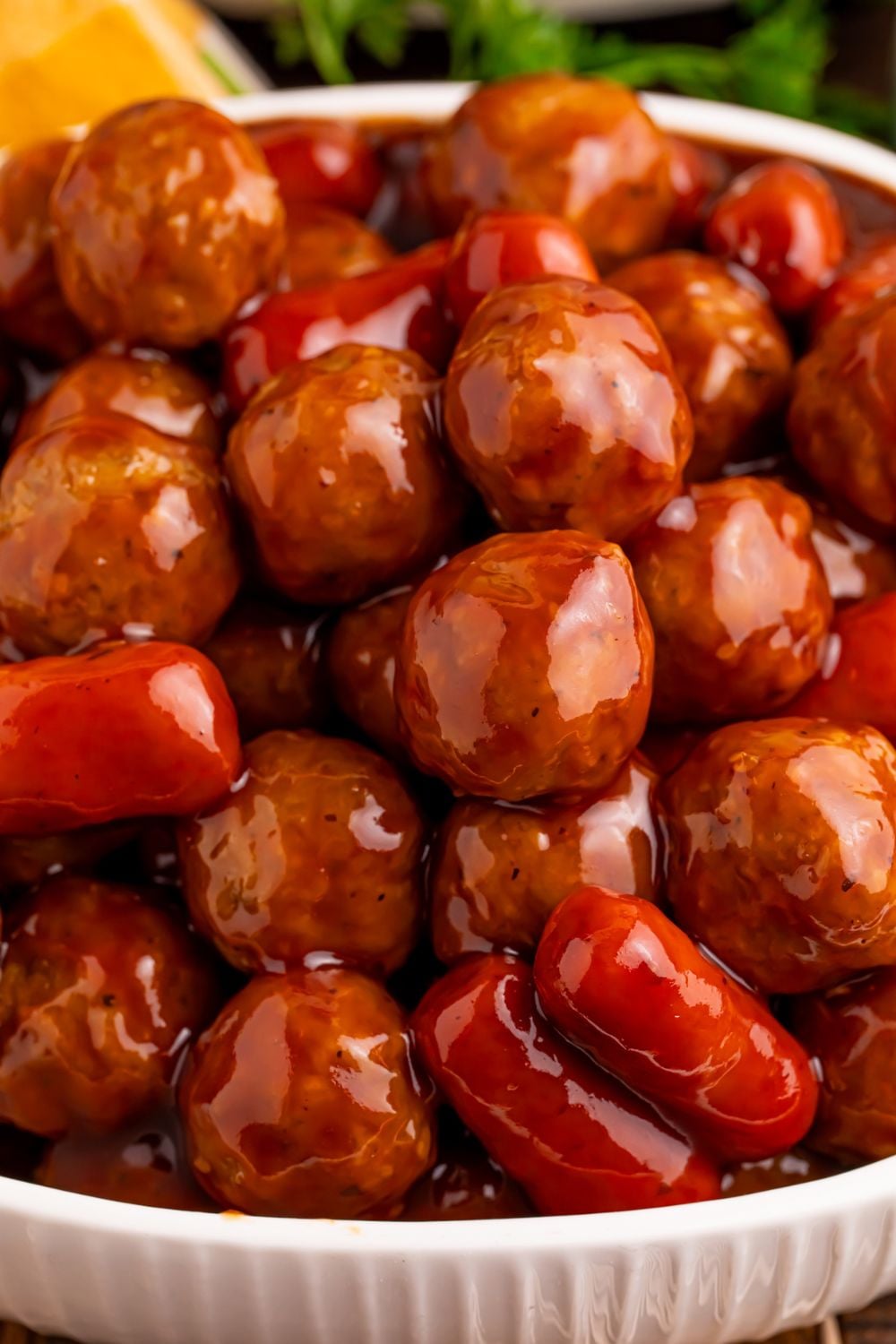 close up look of Crockpot Teriyaki BBQ Cocktail Meatballs & Lil Smokies piled on top of each other in a bowl on table 