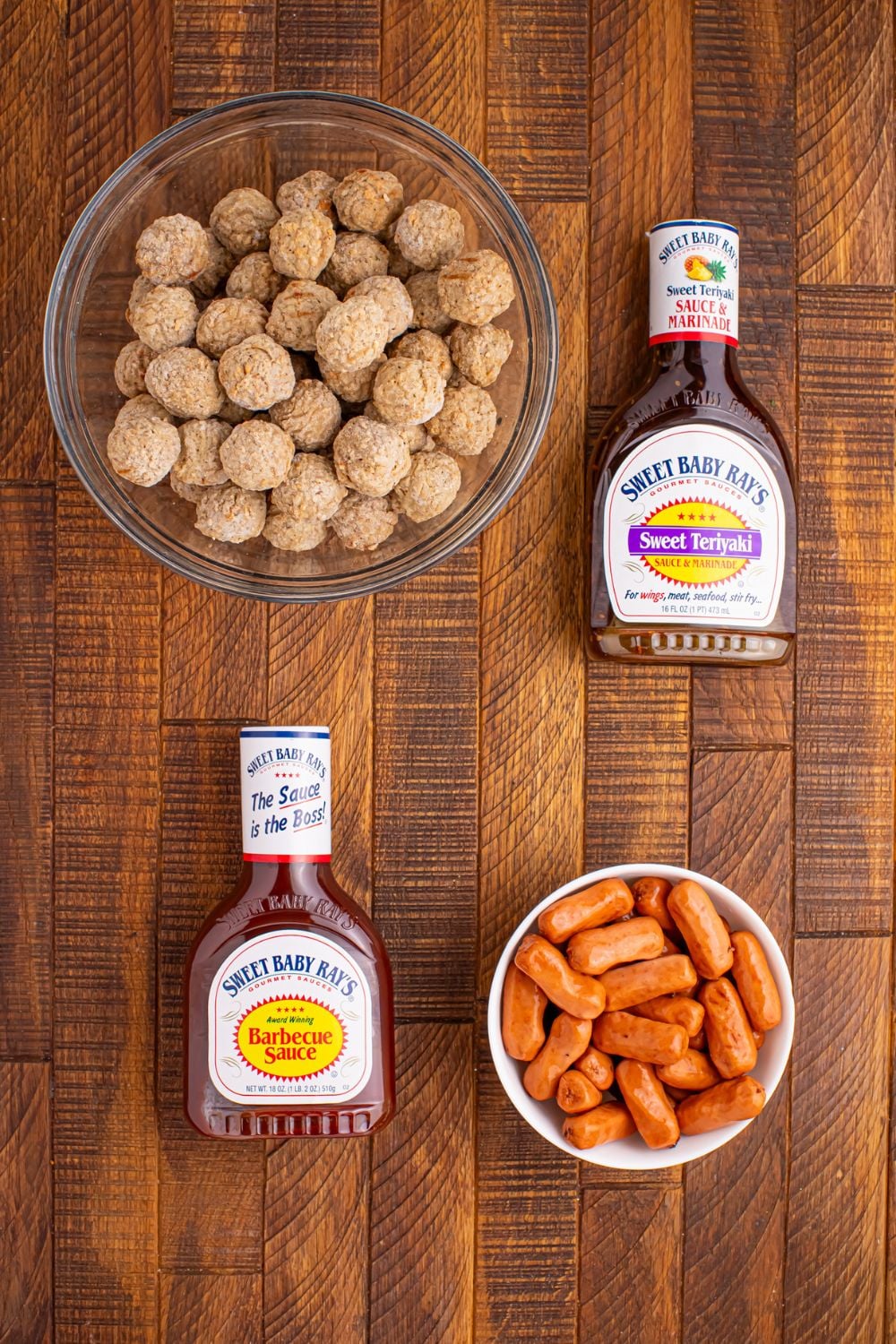 frozen meatballs, two bottles of sauce and little smokies all in bowls on table for making the party appetizer 