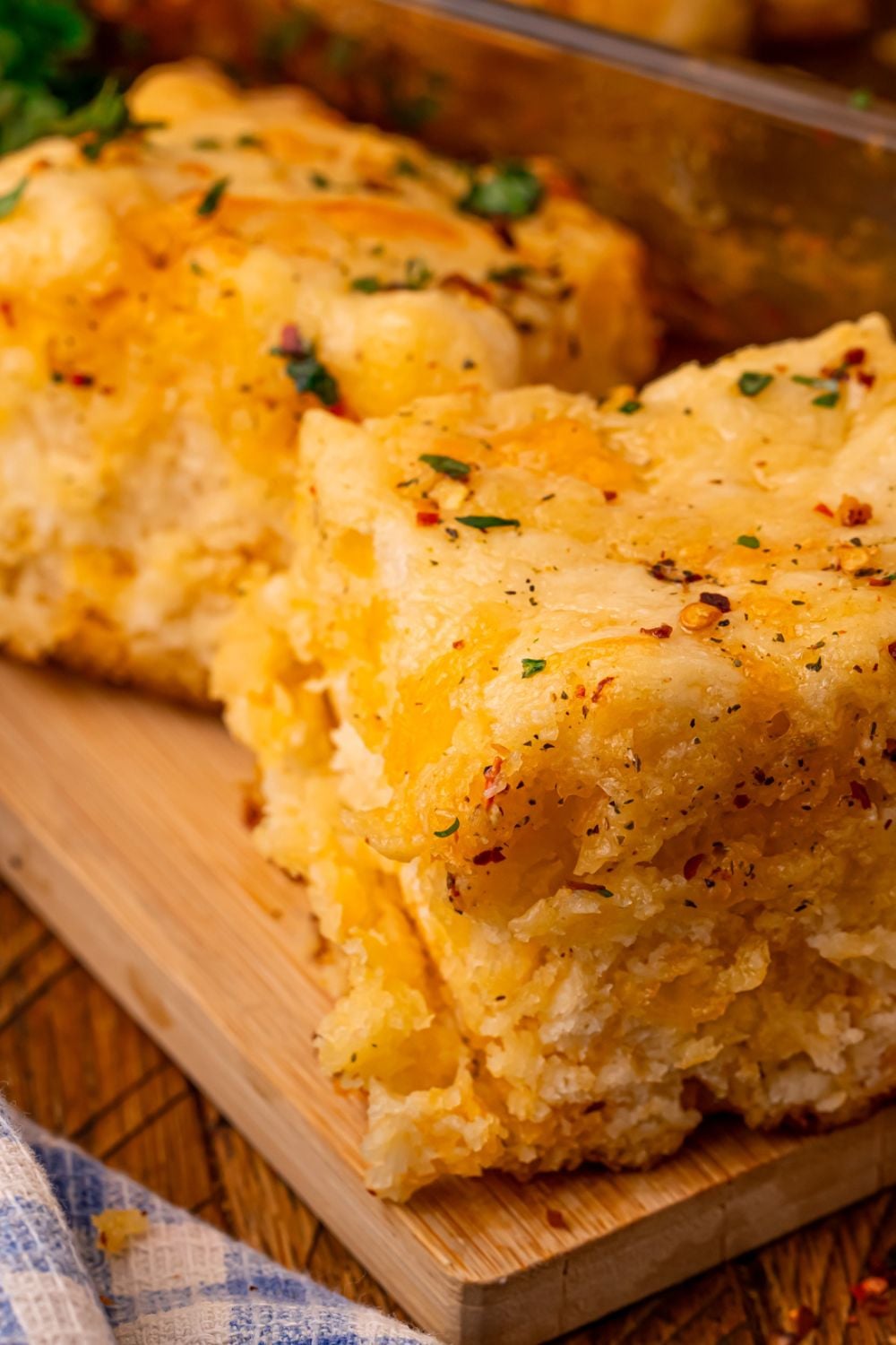Cowboy Butter Swim Biscuits with two biscuits on the table showing the cheesy and buttery look