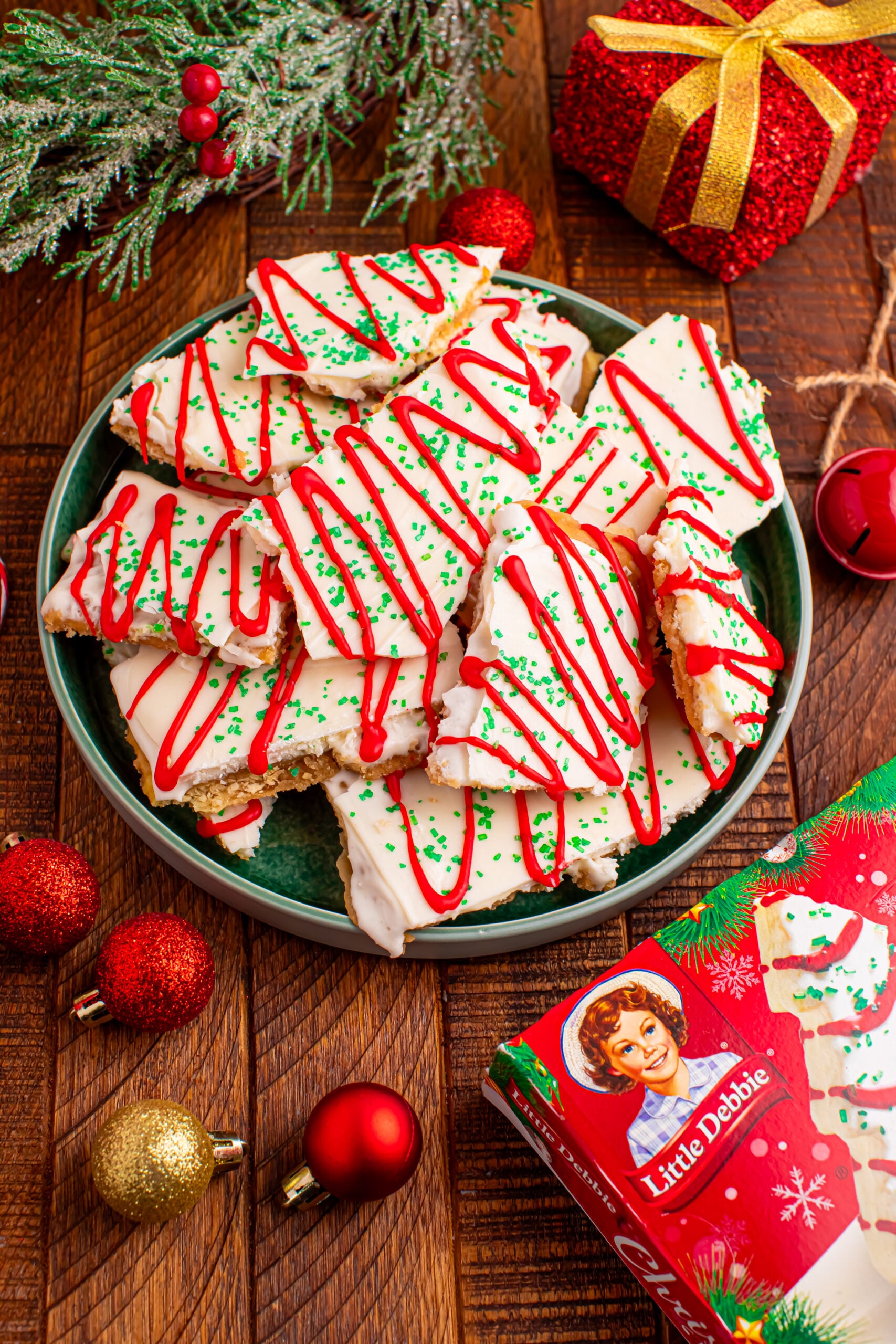 Christmas Tree Crack piled on a green serving platter on a dark wood table surrounded by christmas decorations