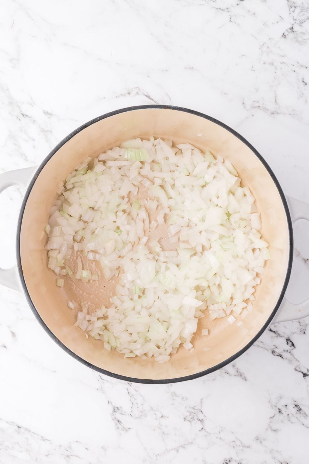 onions in a pot sitting on a marble counter for making southwest chicken soup