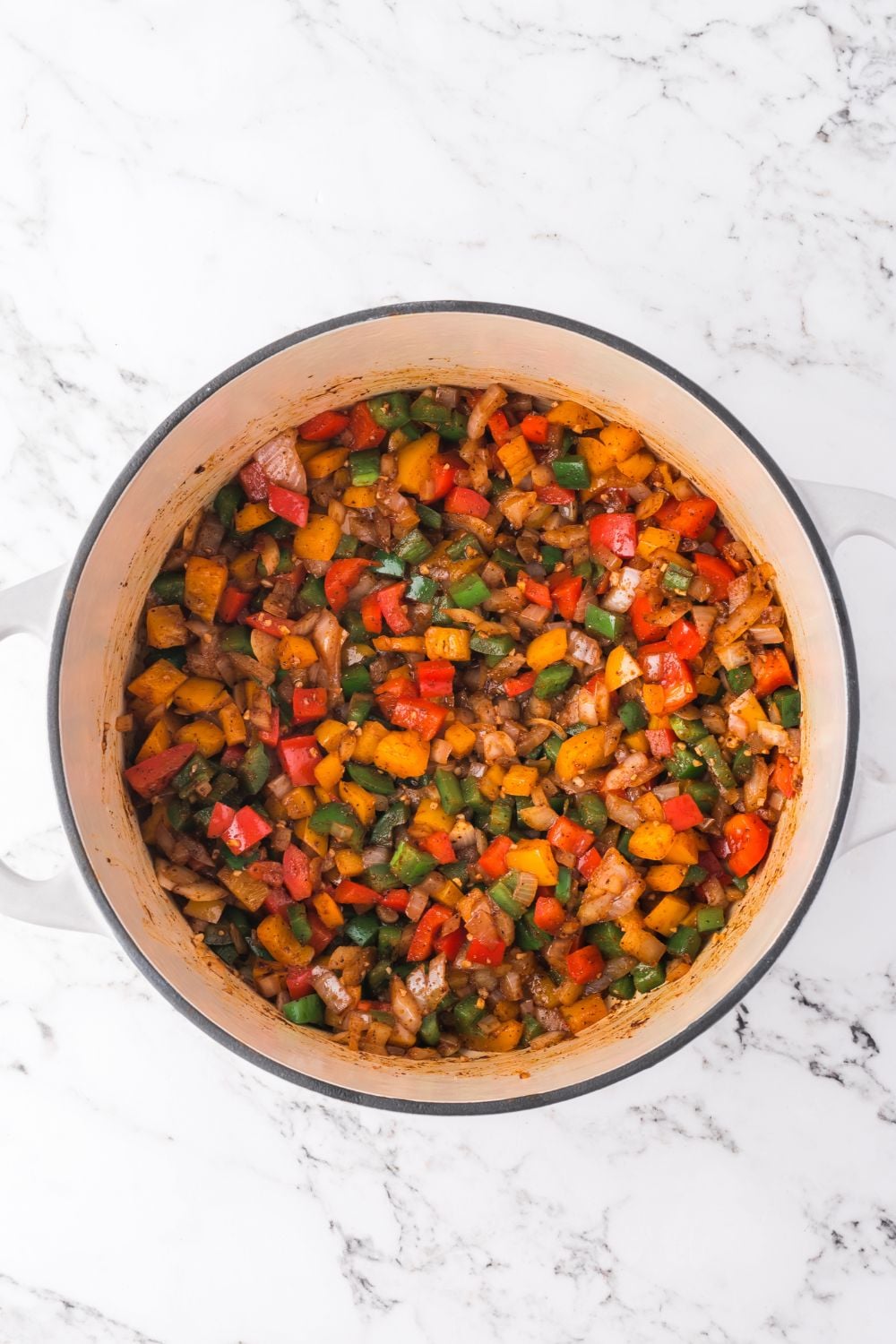 sauteed veggies pot sitting on a marble counter for making southwestern chicken soup