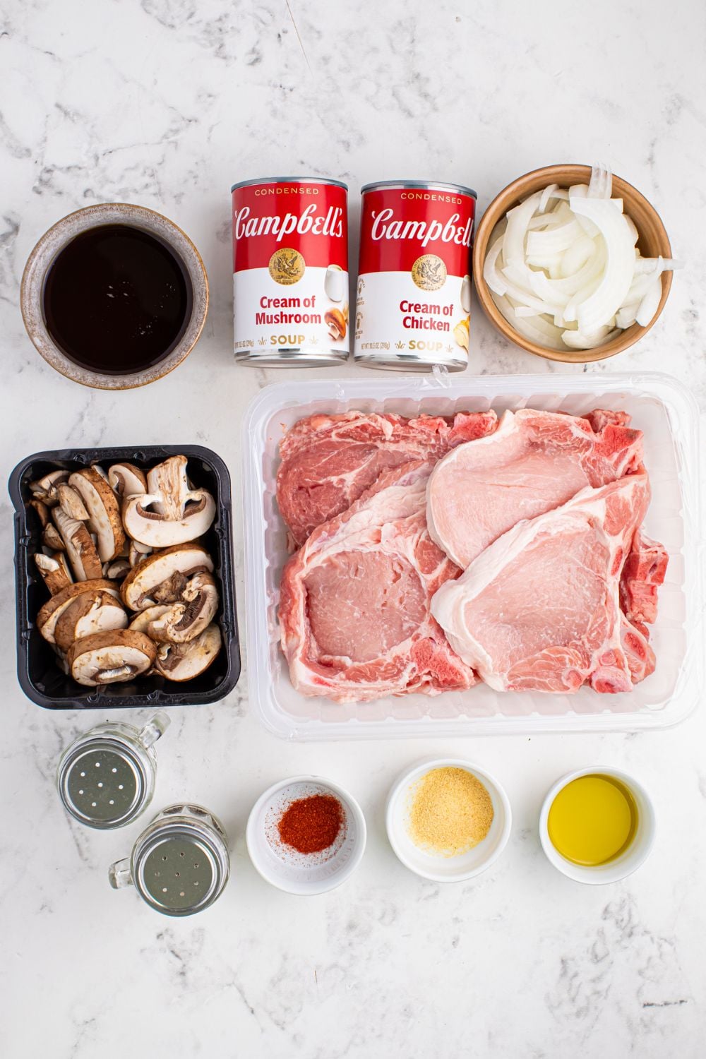 ingredients to make Crockpot Smothered Pork Chops with Mushroom Gravy on a marble counter 