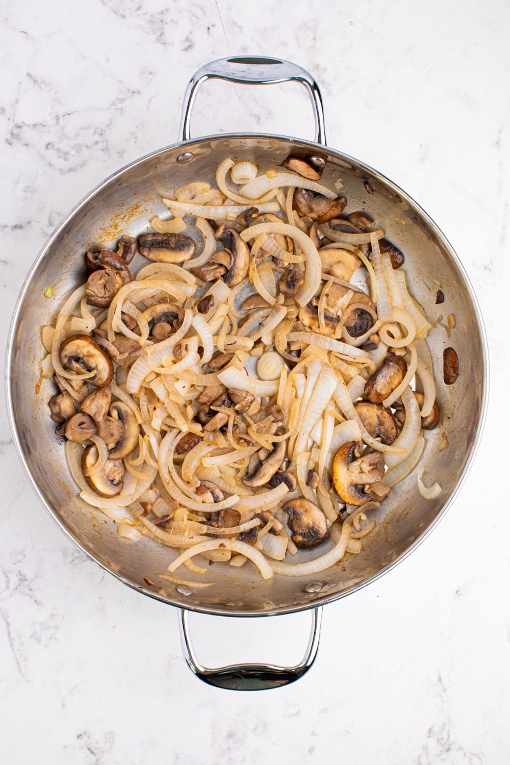 skillet with mushrooms and onions on a table