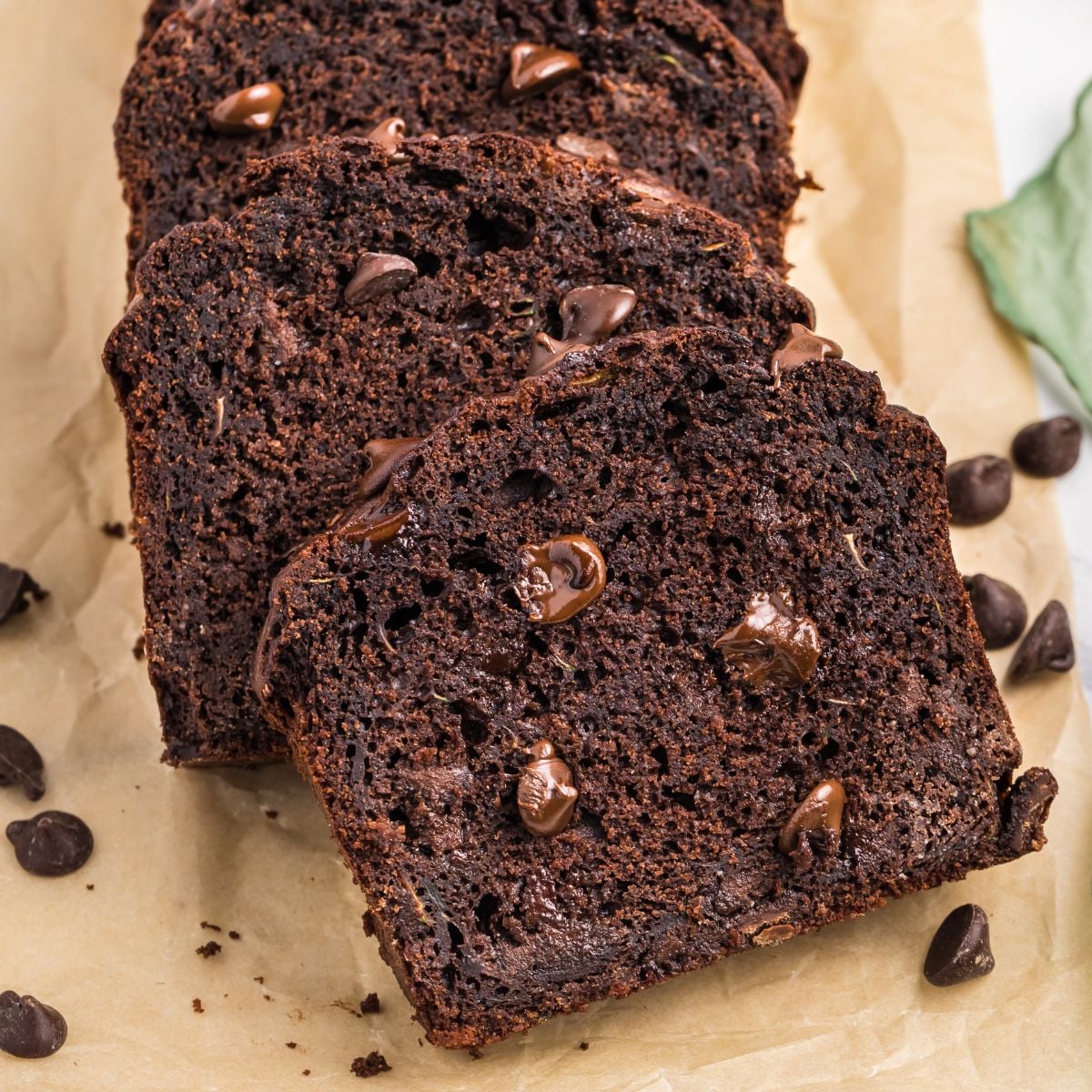 sliced Double Chocolate Zucchini Bread on a table with chocolate chips