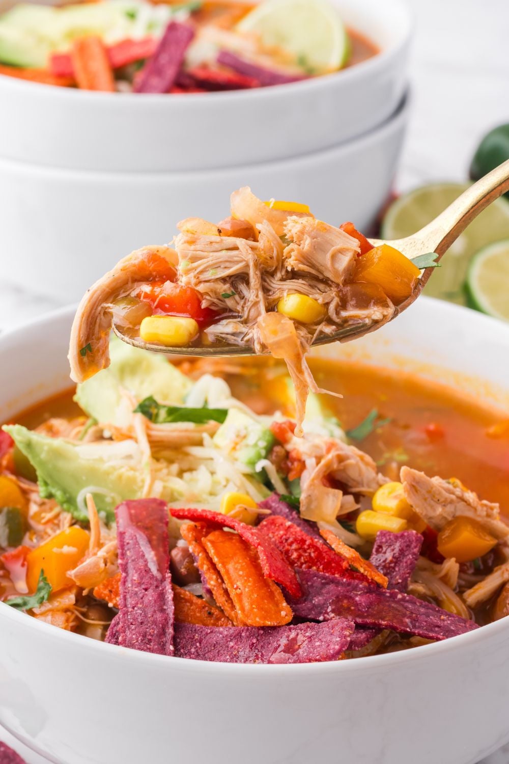 Southwestern Chicken Soup in a white bowl with a spoon full of soup lifting out of the bowl