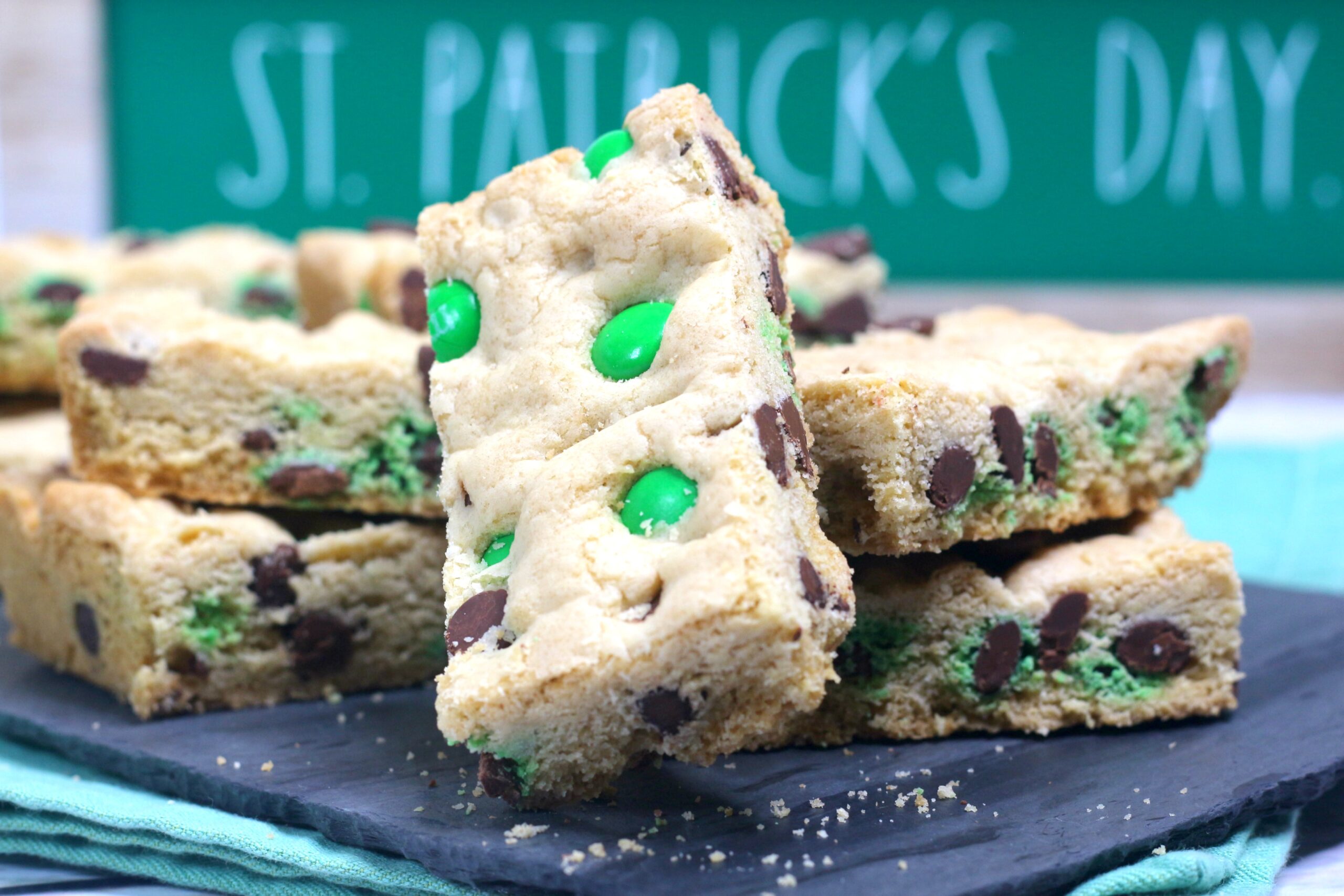 Saint Patrick's Day Chocolate Chip Cookie Bars on a black serving tray with st paddys day decor