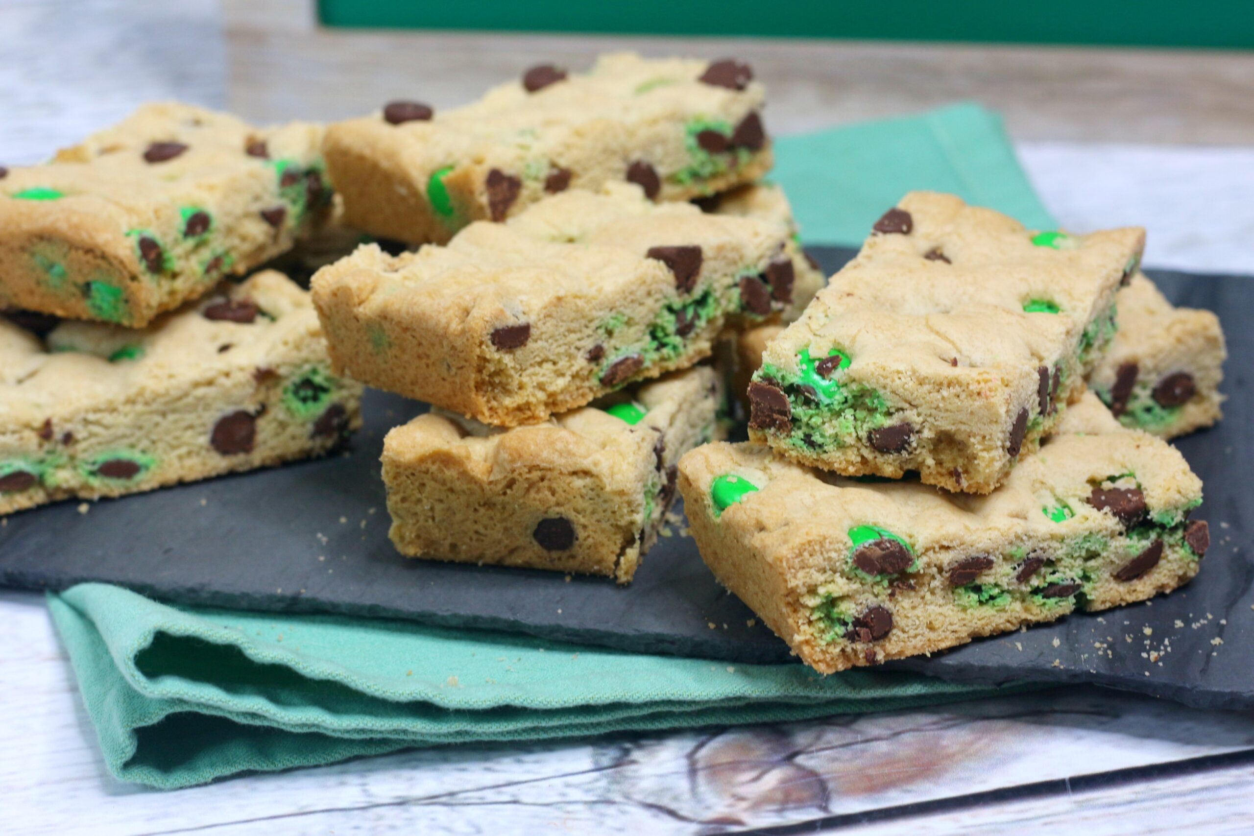 Saint Patrick's Day Chocolate Chip Cookie Bars on a black serving tray with st paddys day decor